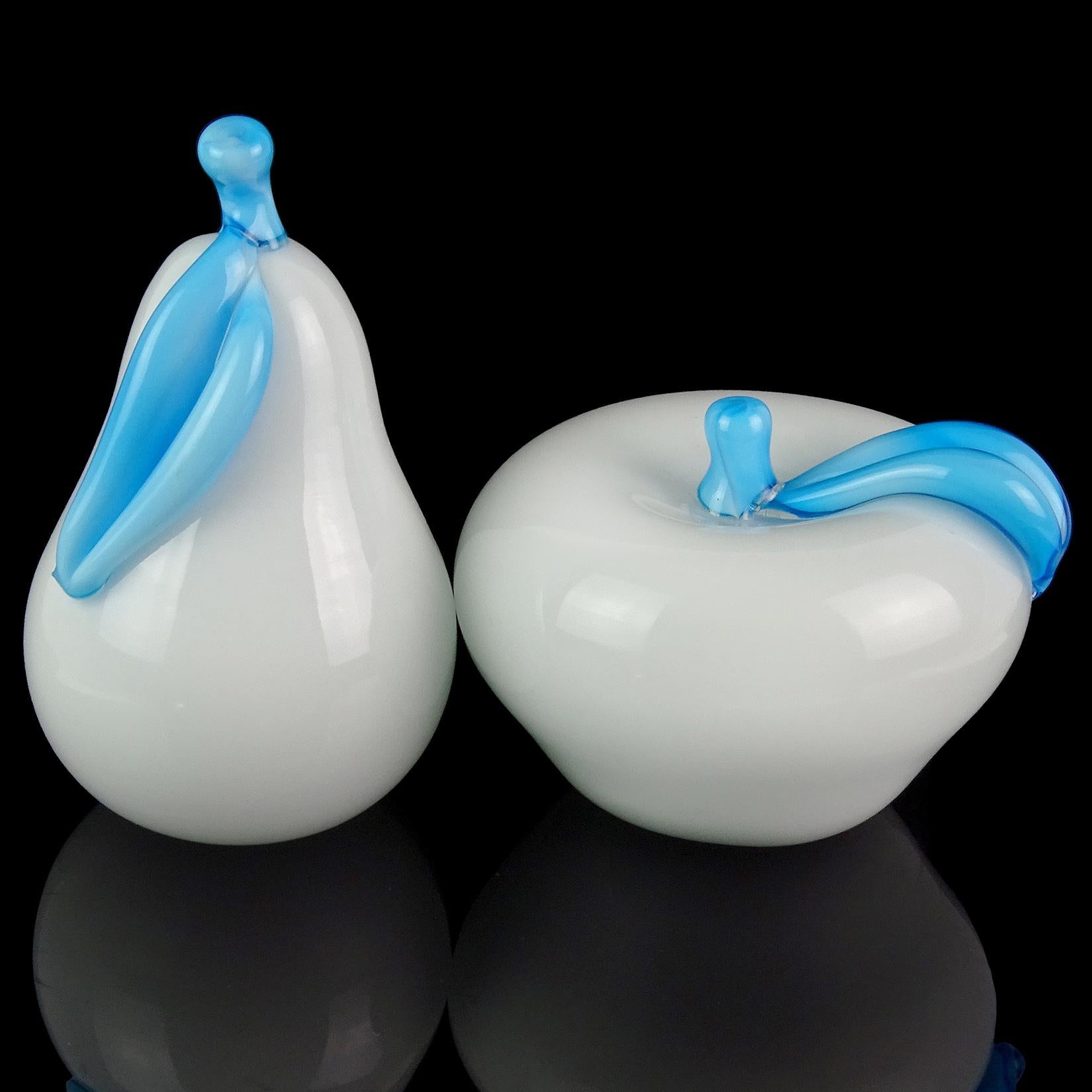 Precioso juego de frutas de Murano soplado a mano en blanco brillante y azul cielo. Están creados al estilo de los diseñadores Archimede Seguso y Alfredo Barbini. Las esculturas de pera y manzana blancas tienen hojas y tallos azul celeste pegados a