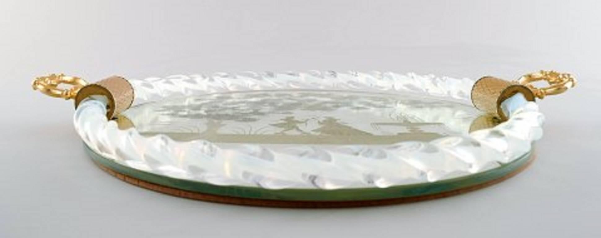 Murano, Italie, plateau rectangulaire avec plaque en miroir, motif floral avec scène galante, deux poignées en métal doré sur le côté.
Longueur environ 34 cm (avec la poignée), profondeur 2,5 cm.
En parfait état.