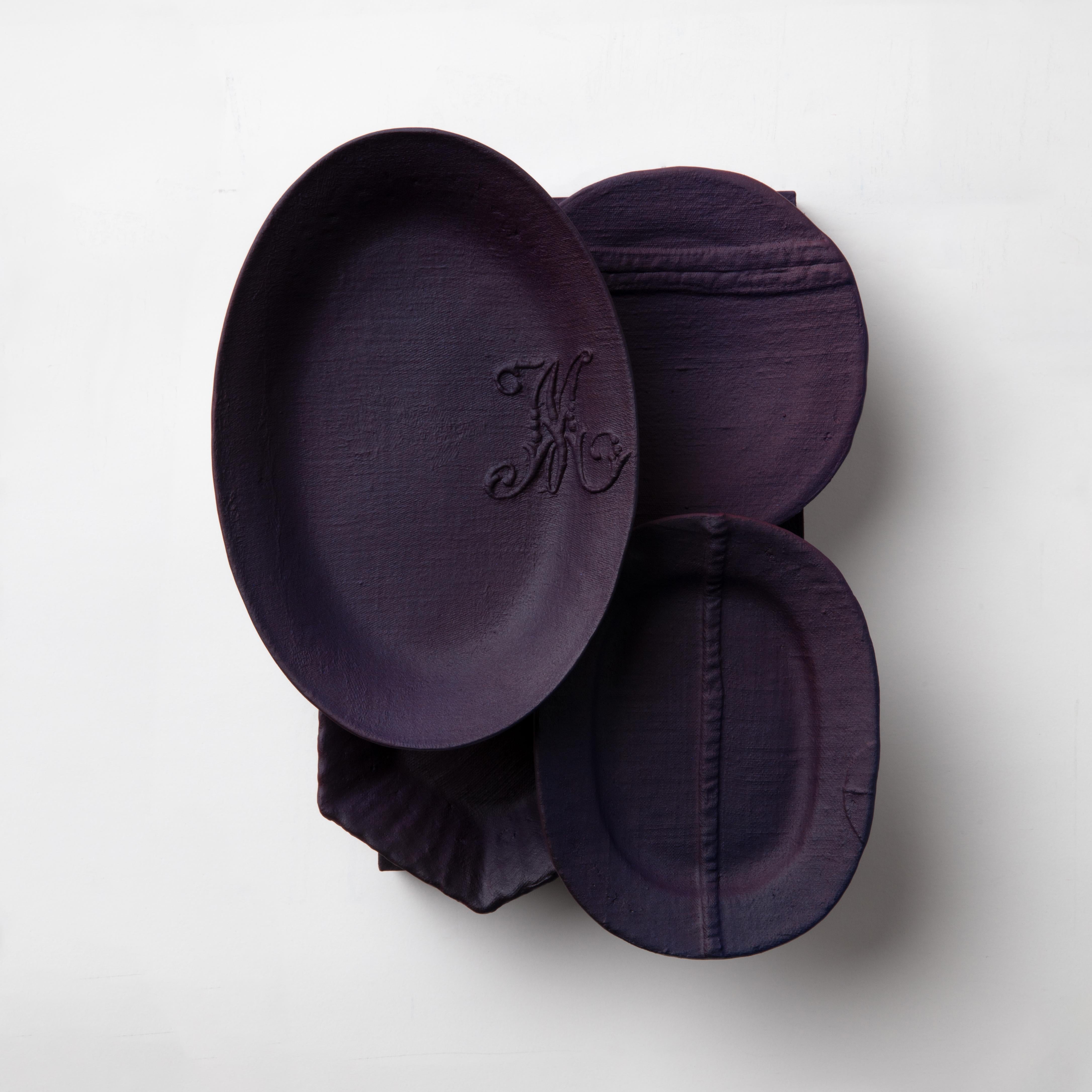 This installation consists of a group of hand made plates in porcelain with our signature fabric texture combined with heritage shapes.

The title Mûre (blackberry in French) references the letter M embroidery on the oval piece on the left of the