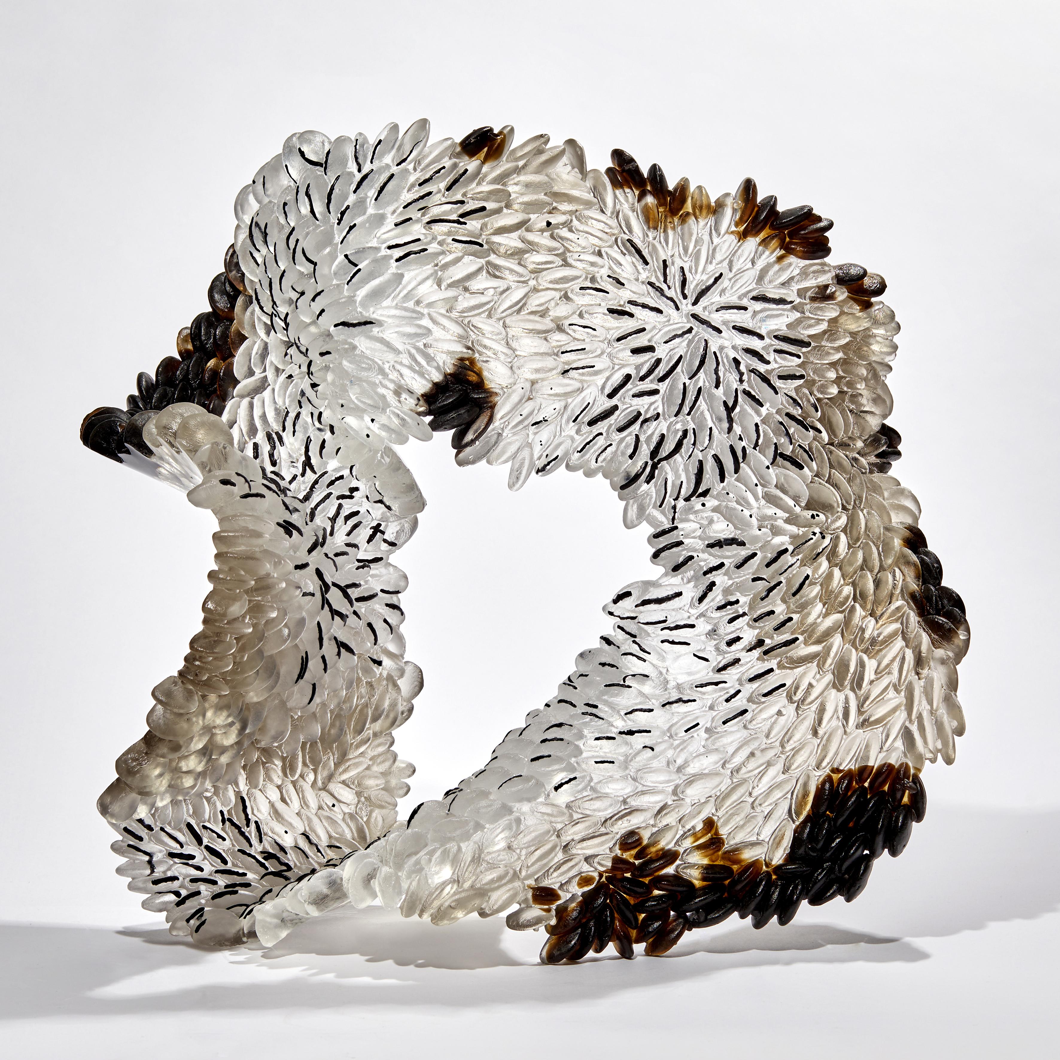 Murmur is a unique textured glass sculpture in clear, dark brown, black and bronze by the British artist Nina Casson McGarva.

Casson McGarva firstly casts her glass in a flat mould where she introduces all of the beautifully detailed, scaled