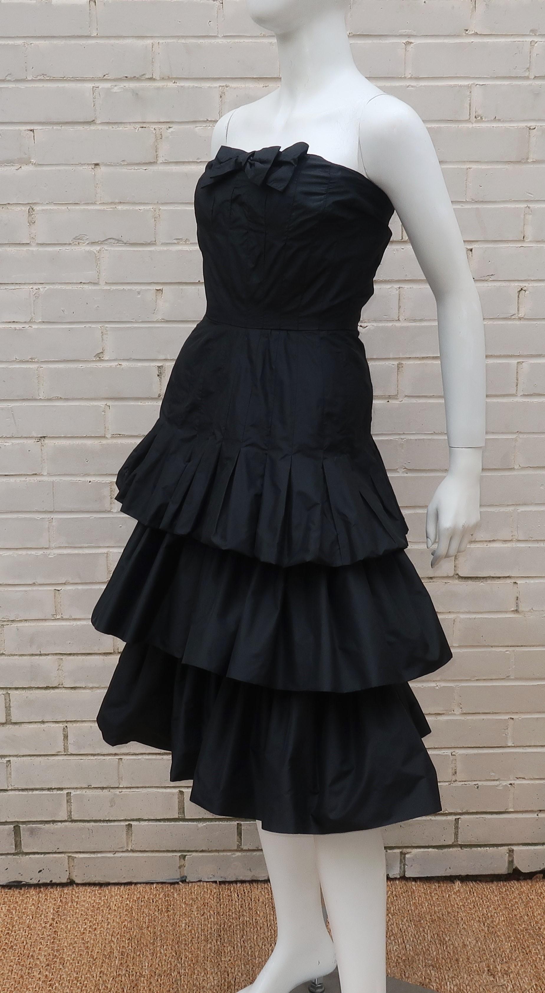 The English designer, Murray Arbeid, was known for his evening wear and often dressed Princess Diana for high profile events.  This silk taffeta strapless black dress has a decidedly youthful look with a bow at the bodice and three layers of ruffled