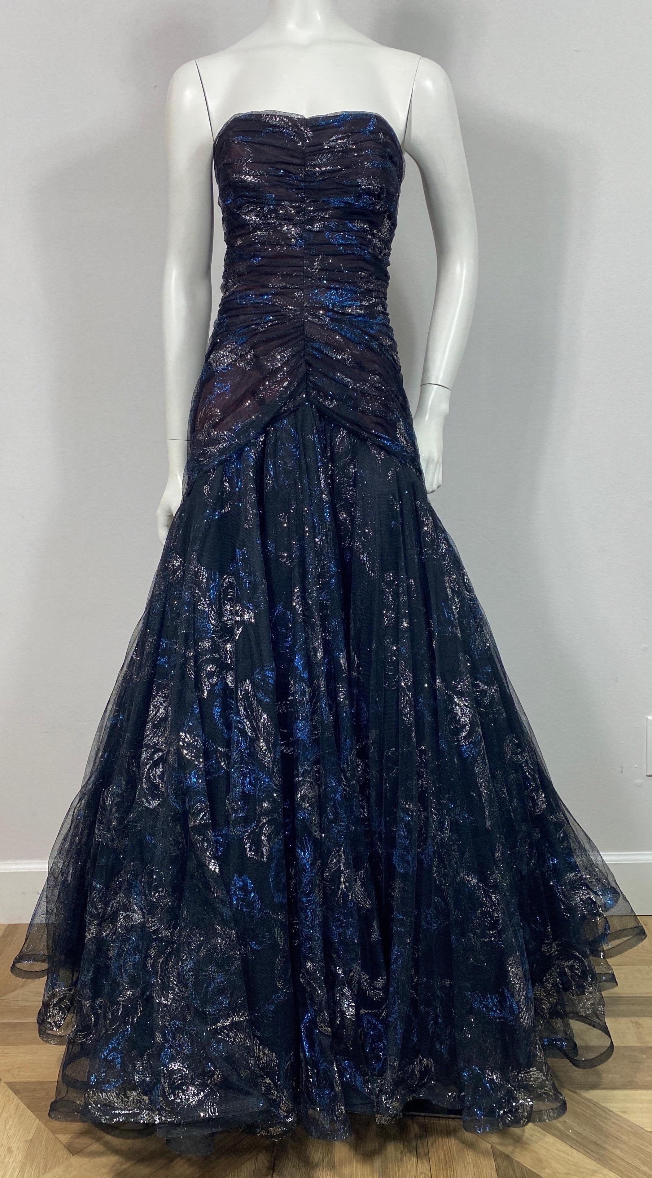 Murray Arbeid Early 1990’s Black Tulle with blue and silver metallic detail through the Gown - Size 8 This late 1980’s or Early 1990’s gown is made of multi layers of tulle and a Black Top Mesh fabric that has and electric metallic blue and silver