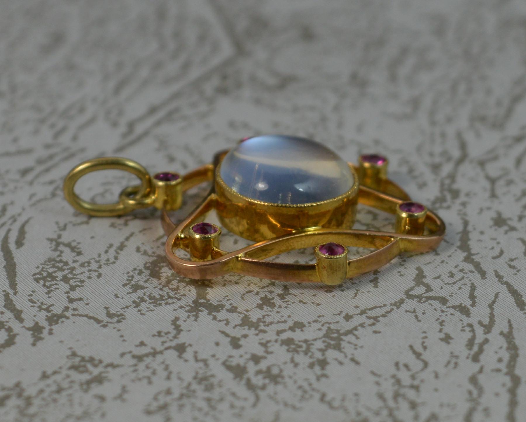 A fantastic Art Nouveau period pendant by Murrle Bennett and Co c1905.
Solid 15 carat gold example.
Designed with a bright round moonstone to centre in bezel setting. Surrounding is a gold flowing shape and set with six small round cut