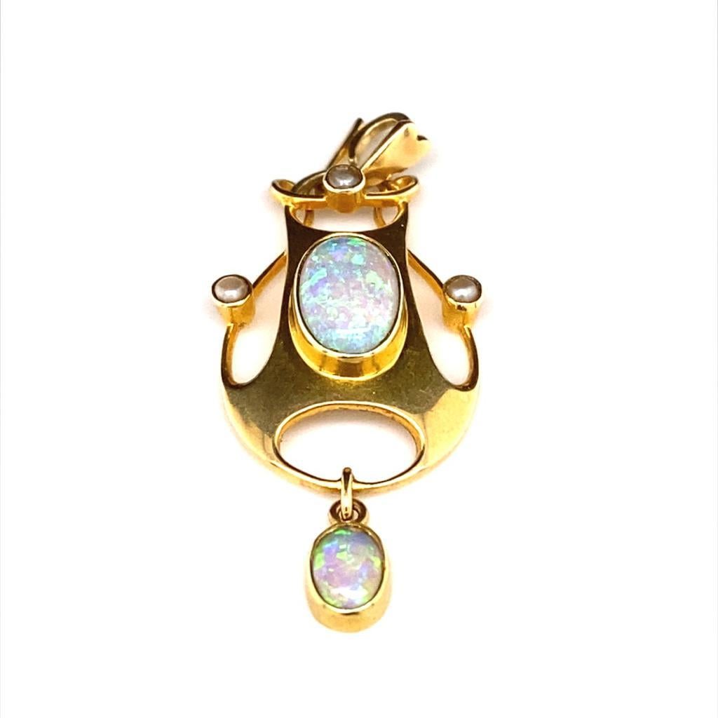 A beautiful Art Nouveau opal and seed pearl pendant by Murrle Bennett & Co

A finely crafted 15 carat yellow gold pendant of swirling oblong design, epitomizing the elegant designs of the period. 

Set to its centre with a cabochon cut opal and