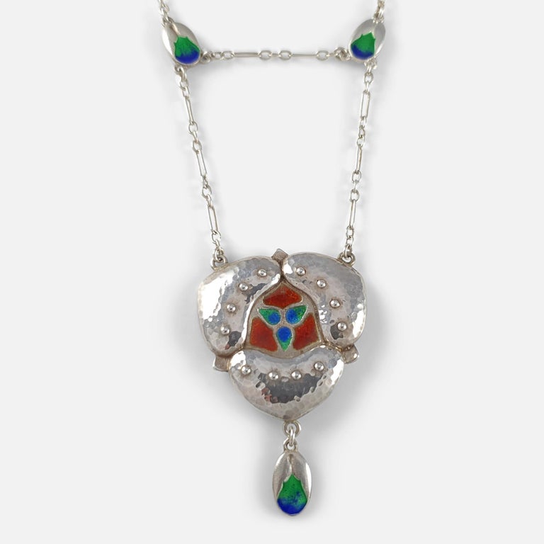 An Arts & Crafts spot-hammered silver & enamel pendant necklace by Murrle Bennett & Co, circa 1905. 

Stamped '950', & 'MBCo' for Murrle Bennett and Co.

Period: - Early 20th Century.

Date: - Circa 1905.

Engraving: - None.

Measurement: - The