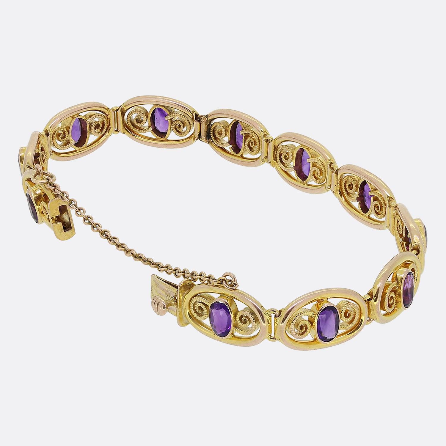 Here we have lovely vintage piece from Murrle Bennett & Co. This bracelet's open frame is comprised of multiple oval shaped links, each playing host to a single bezel set oval shaped amethyst flanked on either side by a beaded swirling motif.