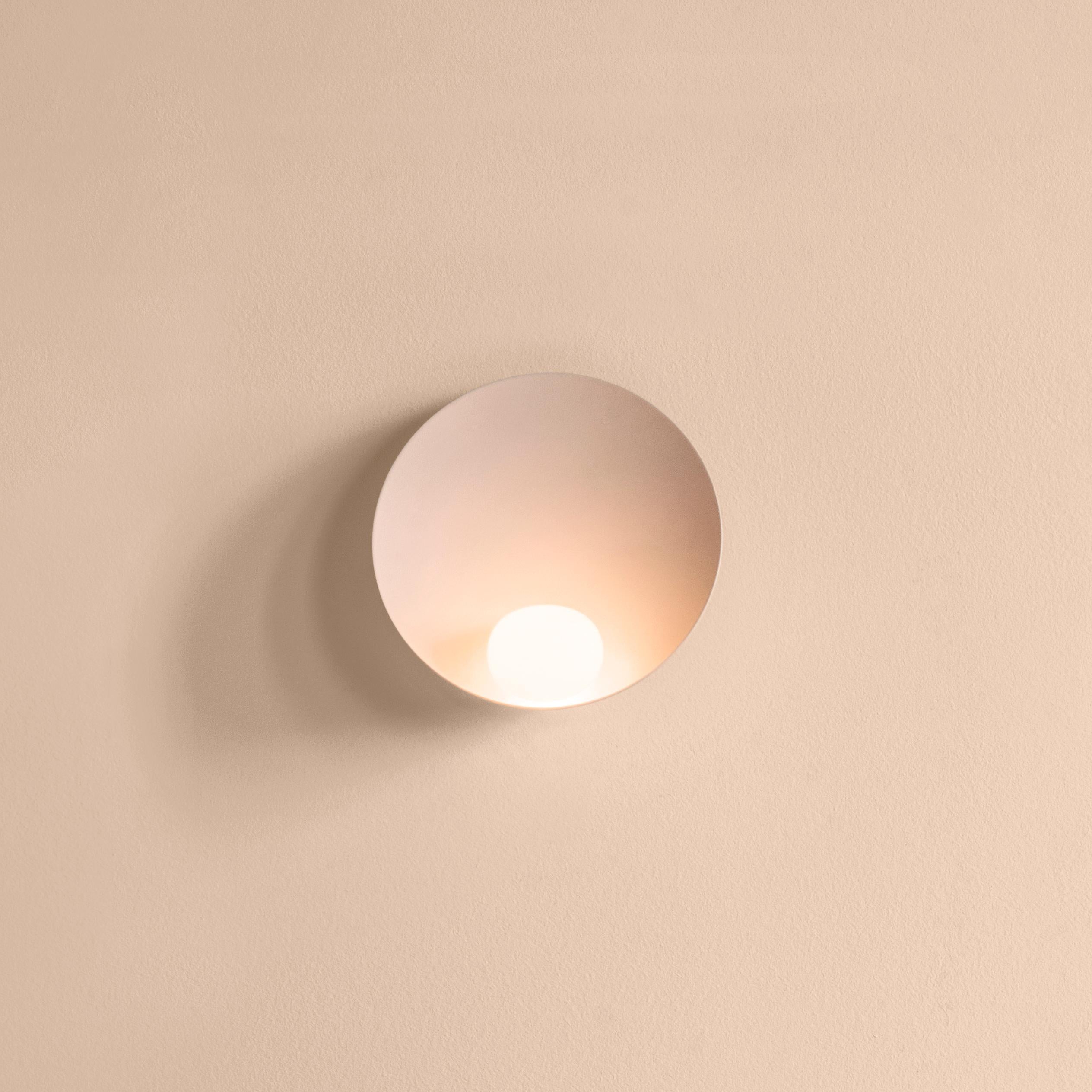 Musa, made from an aluminum base with a triple blown-glass opal diffuser, combines delicacy and subtlety. The base captures light as the small glass sphere transforms it into a soft illumination. The wall lamp remains cool to the touch thanks to an