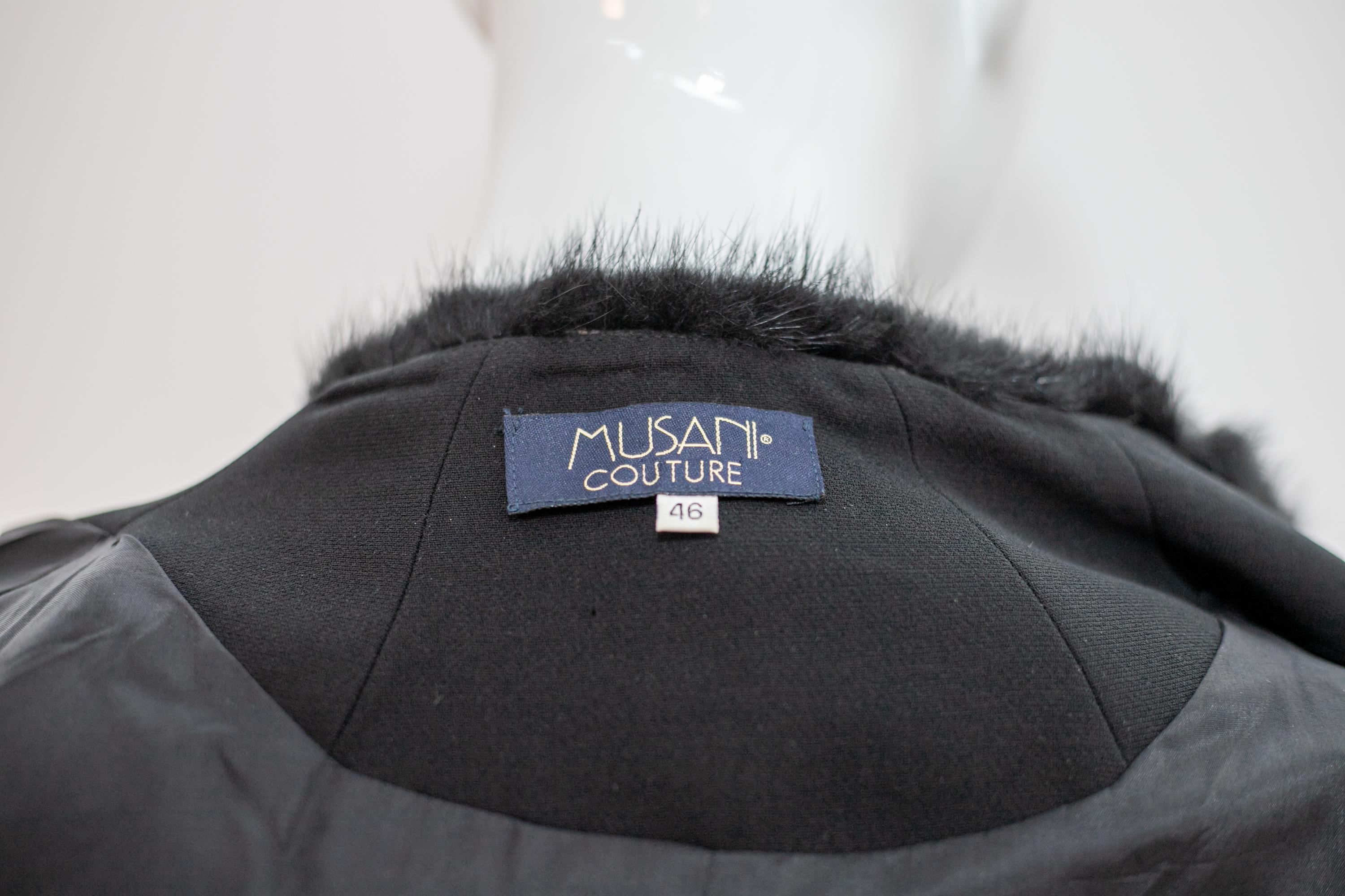 Estrous vintage wool coat from the 1980s by Musani, made in Italy.
ORIGINAL LABEL.
The coat is totally made of black wool and black fur and has long sleeves with wider cuffs, lined with fur at the wrist, definitely high. The collar has the classic