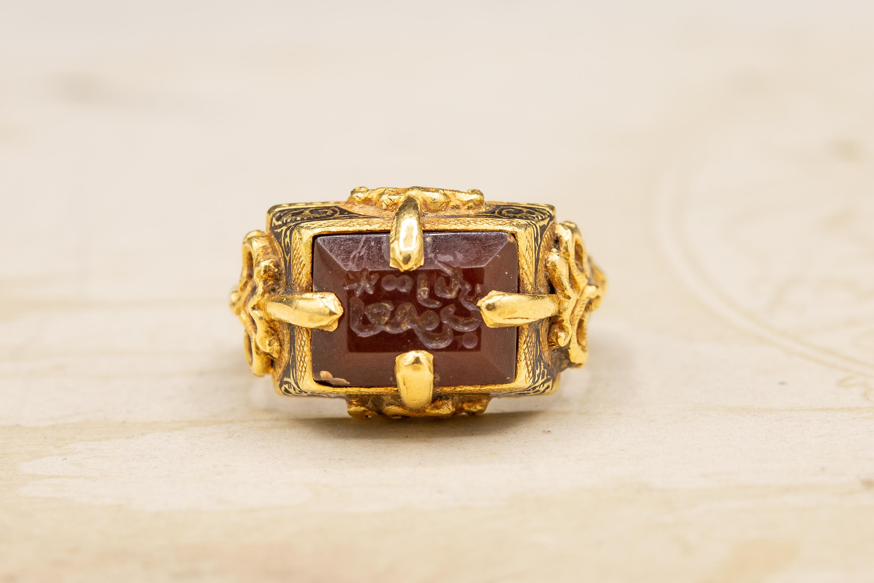 This incredible gold ring dates from the 12th century Seljuk dynasty. The carnelian intaglio is set within a typical Seljuk tapered rectangular bezel with a four-pronged gold setting soldered to the outside of the bezel. Applied and pierced