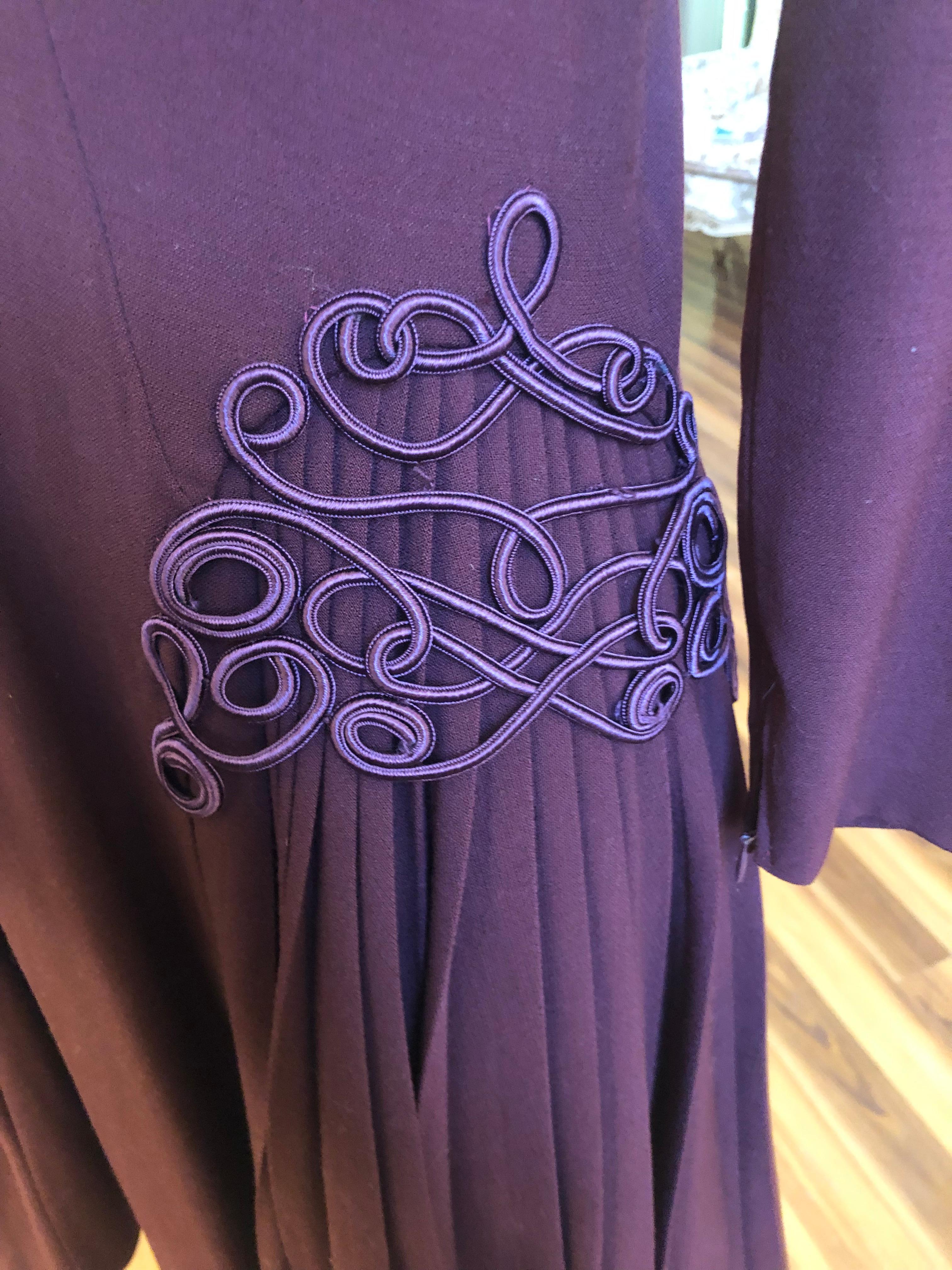 This is an incredible 1940s  Jacques Fath Dress (Jacques Fath passed away in 1954) in excellent condition. Some of the details are decorative braiding; soft pleats; longer side hems; darting, and zips at cuffs.

The color is aubergine, and there is