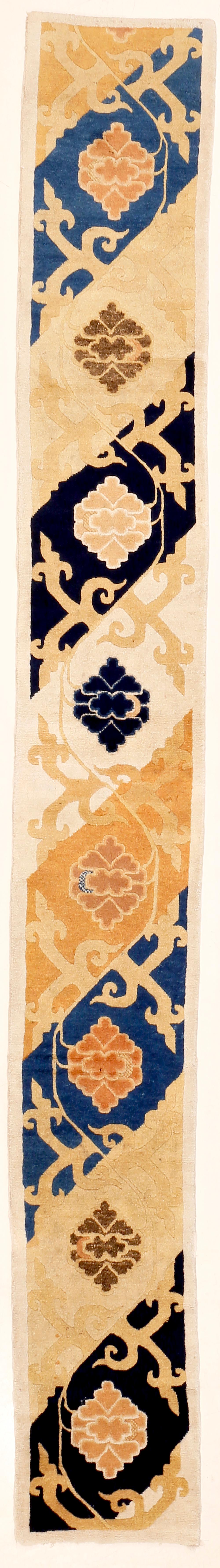 Un tapis à colonnes long et étroit très inhabituel, décoré de grandes fleurs de lotus avec des tracés qui rappellent les tissages de la période Ming. Il est très finement tissé avec de la laine lustrée et il est en excellent état. J'ai vu trois