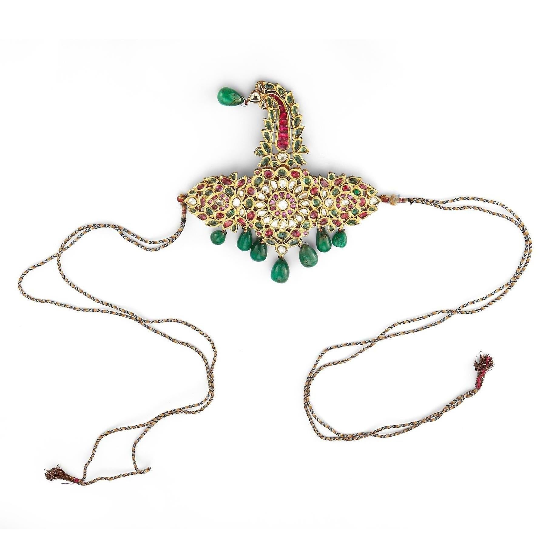 Museum Quality Antique Indian Sarpech Necklace 

Rose cut emeralds, rubies & diamonds set in 22k gold with 8 emerald bead drops. Reverse with very fine hand enamel designs.
With adjustable cord

Originally a turban ornament, it can be worn as a