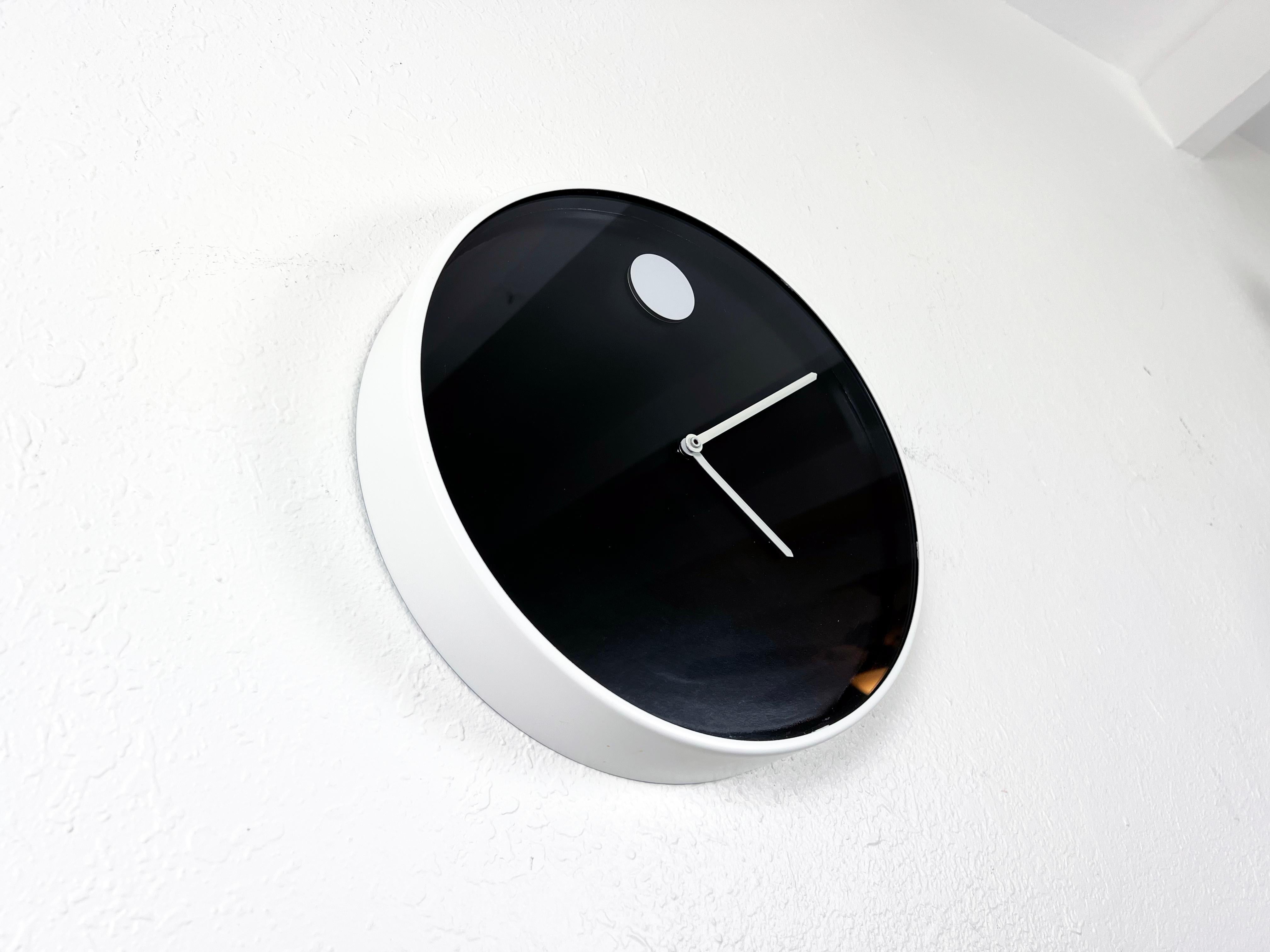 Vintage minimalist circular wall clock with white enameled metal case by Nathan George Horwitt for Howard Miller. Featured in the 1970's design collection of the Modern Museum of Art in New York City. 

Designer: Nathan George