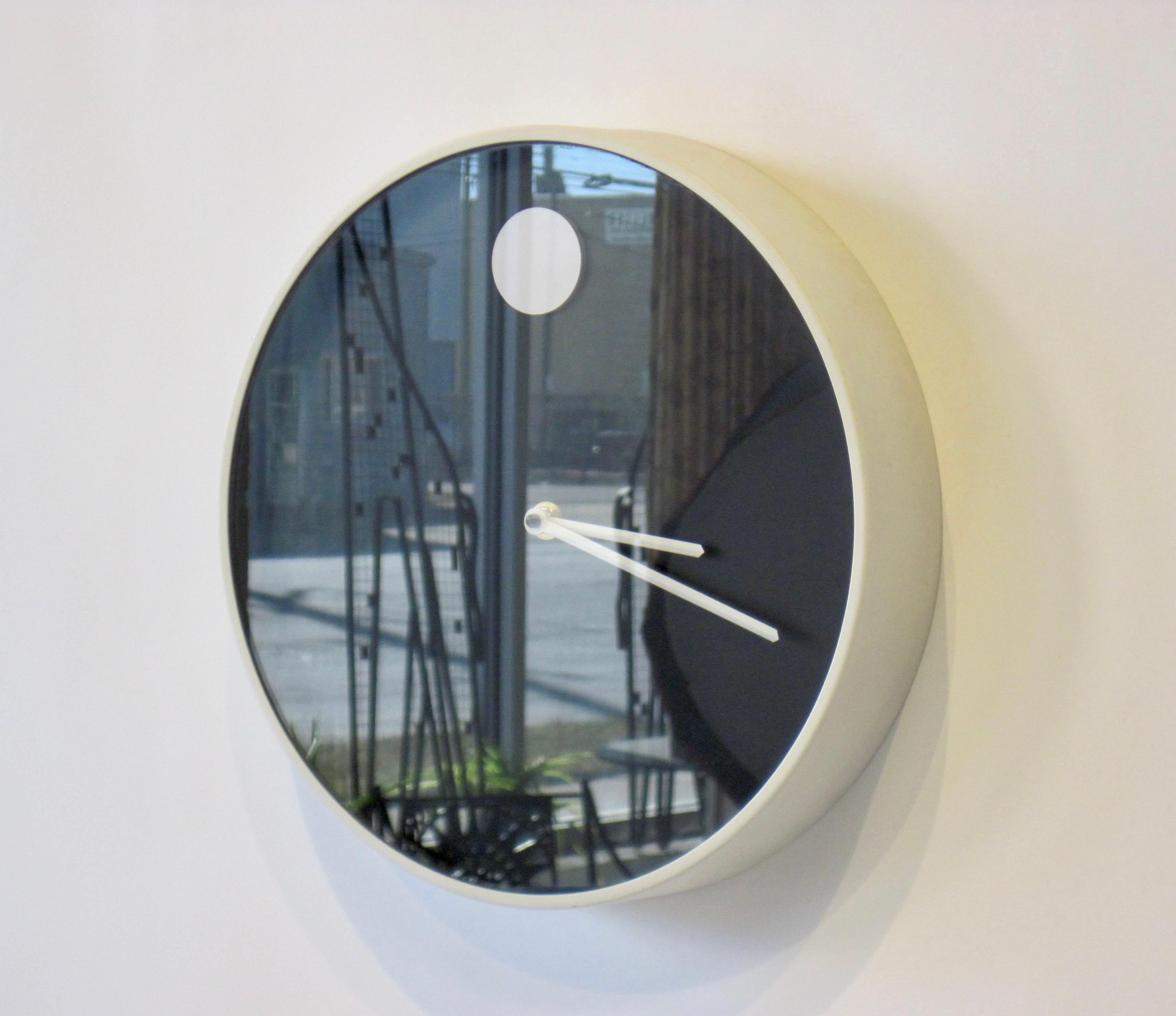 Mid-Century Modern museum wall clock designed by Nathan George Horwitt for Howard Miller Clock Company, Zeeland Michigan.
Movado style Minimalist design in black and white. The outer casing is enameled in eggshell white with a black face with white