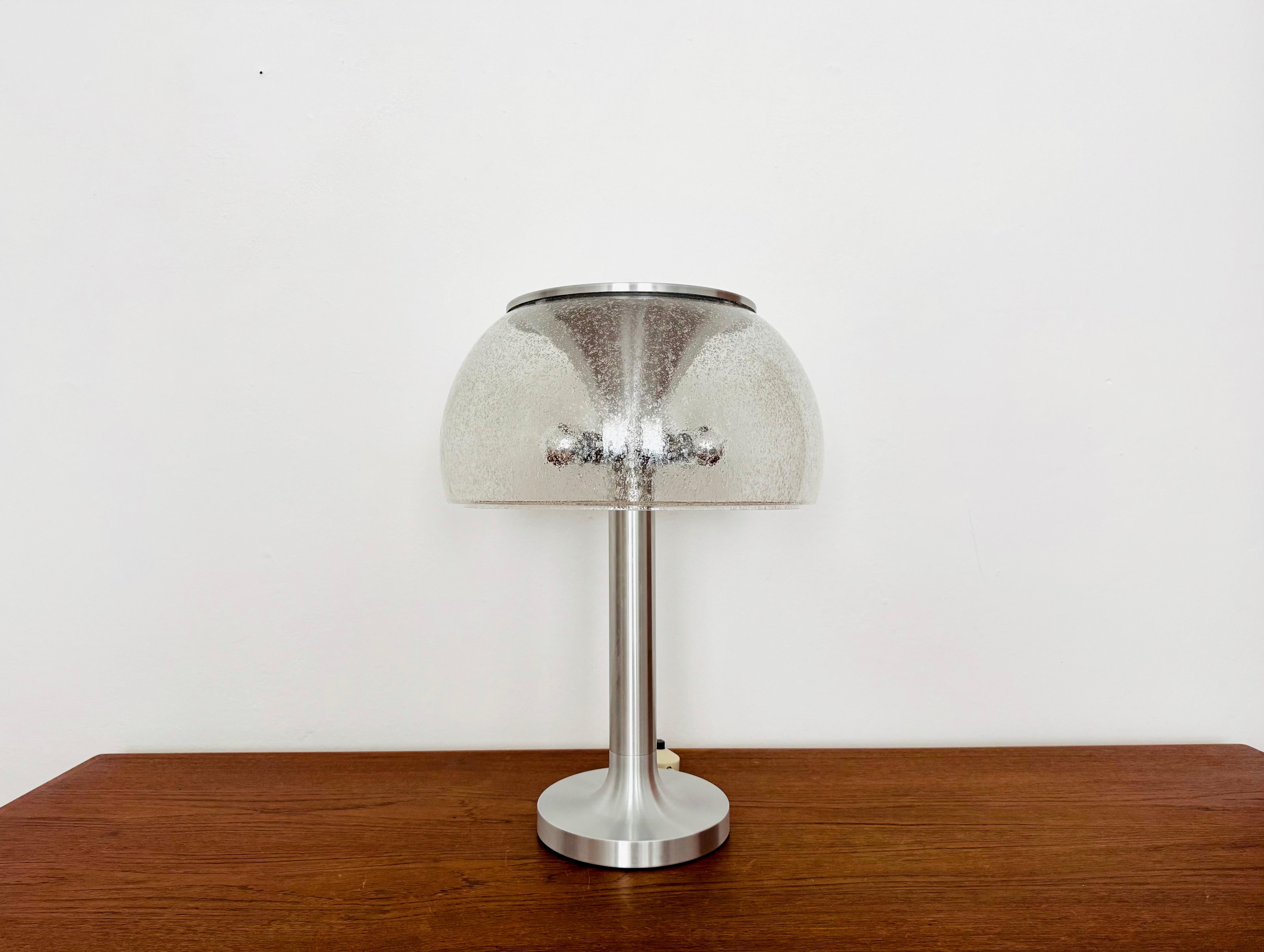 Wonderful table lamp with an impressive glass lampshade from the 1960s.
Exceptional design and an enchanting light object.
The lamp creates a wonderful lighting atmosphere and is a great addition to any home.
A double switch allows you to vary the