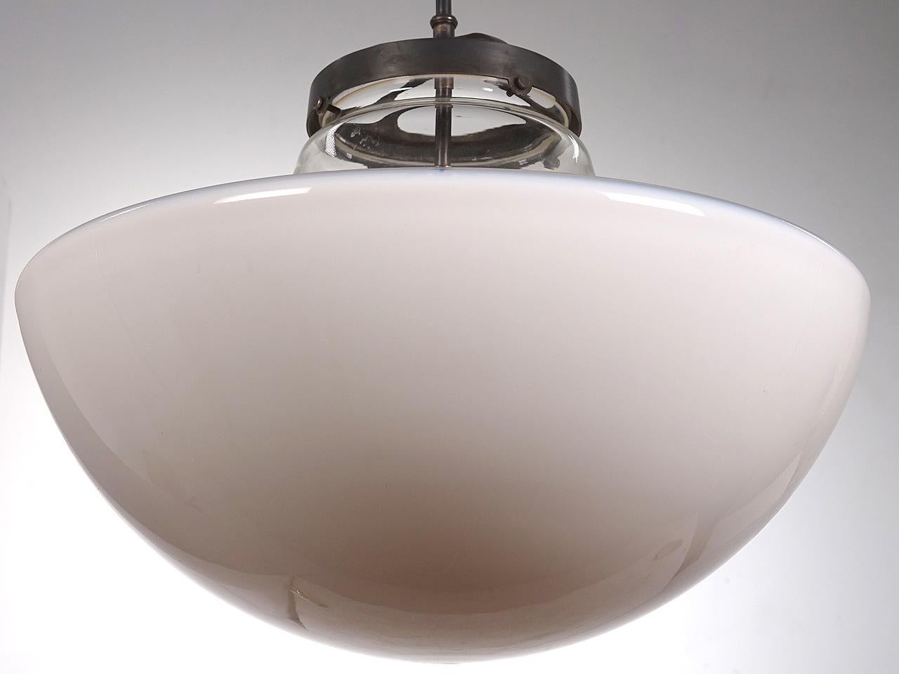 This is a large and impressive lamp. The globes have an 18 inch diameter. They have a midcentury look but could even be earlier. The shape is an inverted mushroom with the under dome in translucent white and the top neck clear. They are priced per