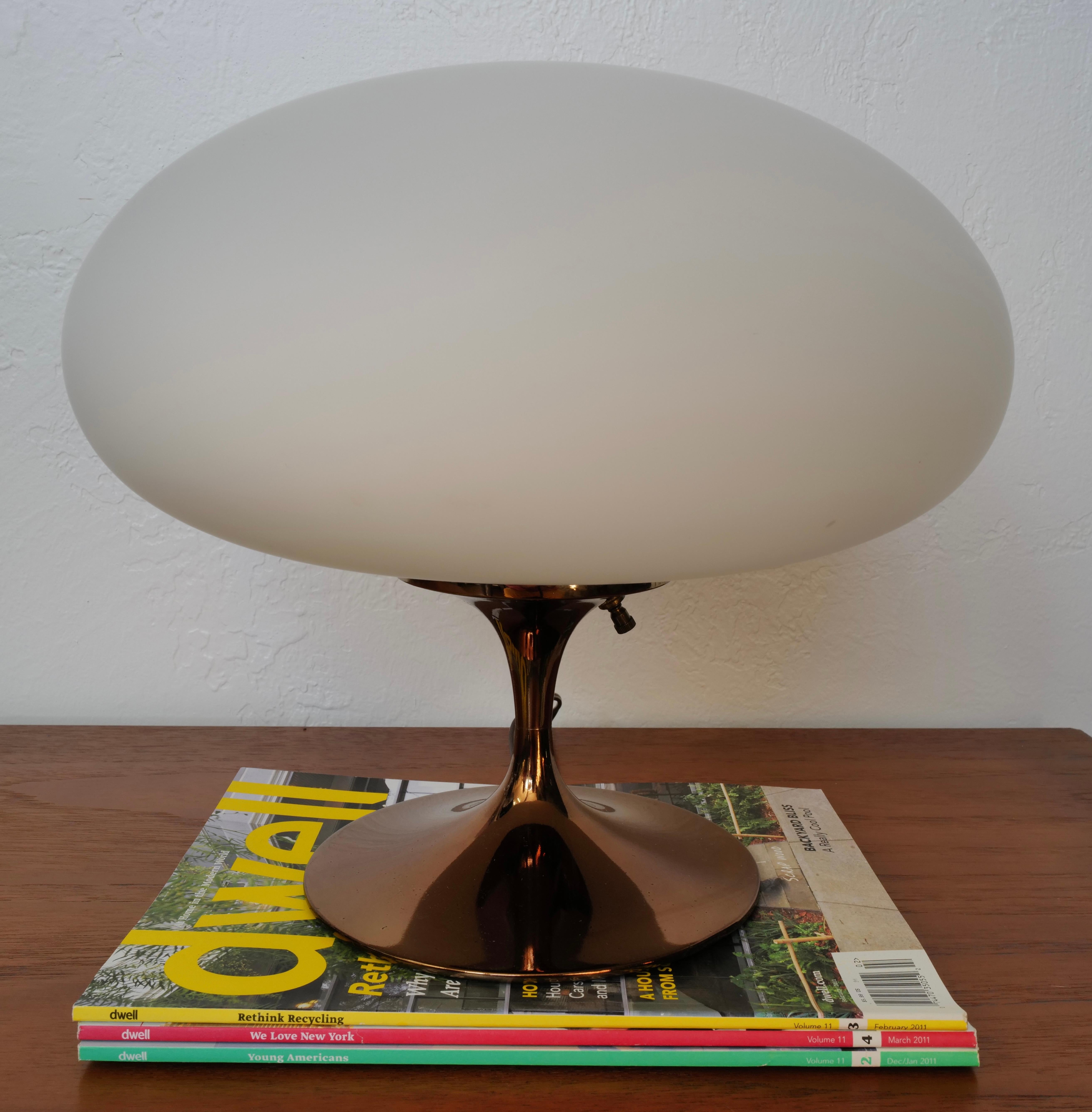 A stunning shiny bronze finished mushroom table lamp by Laurel Lamp Company. This elegant piece is complemented by its delicate glass shade, adding a touch of sophistication to any space. Simple on and off switch on body of lamp. Place a color