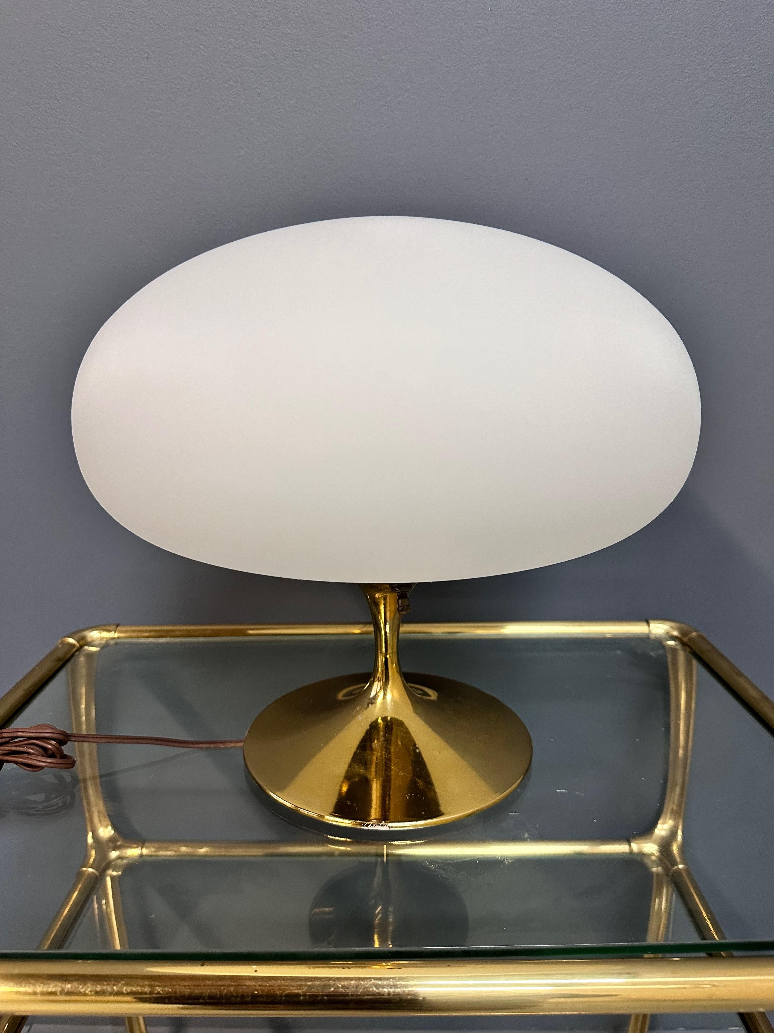 A stunning shiny brass finished original mushroom table lamp by Laurel Lamp Company. This elegant piece is complemented by its delicate glass shade, adding a touch of sophistication to any space. Simple on and off switch on body of lamp. 