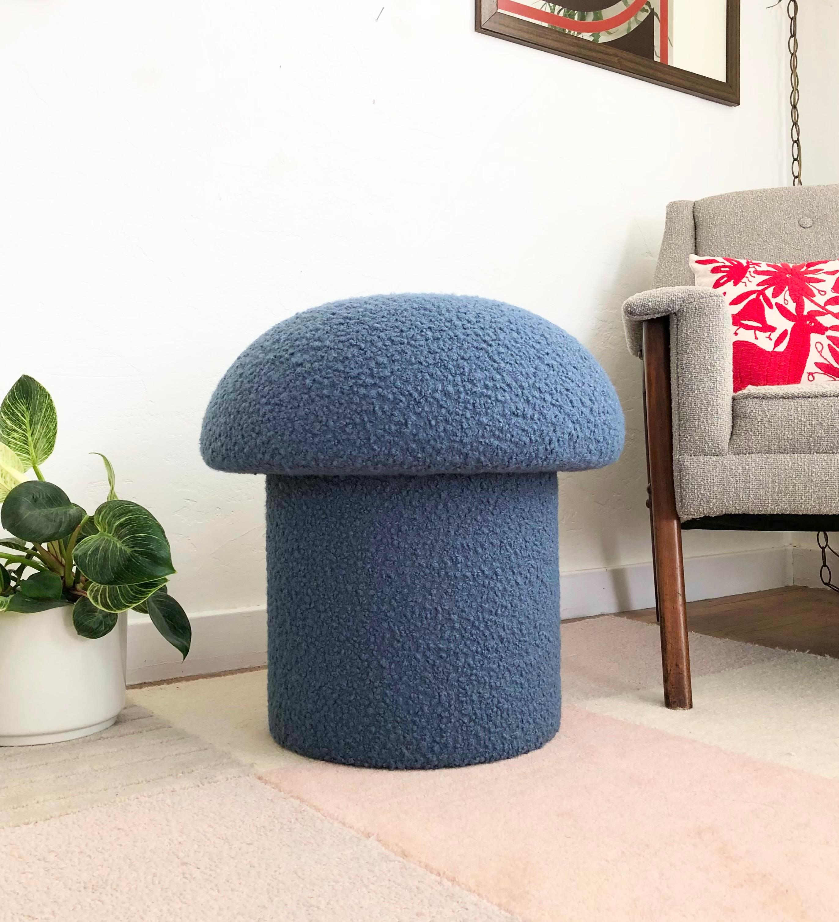 Un ottoman en forme de champignon fait à la main, tapissé d'un tissu bouclé de couleur bleu denim. Parfait pour être utilisé comme pouf ou comme siège supplémentaire d'appoint. Un siège coussiné confortable et une pièce d'accentuation