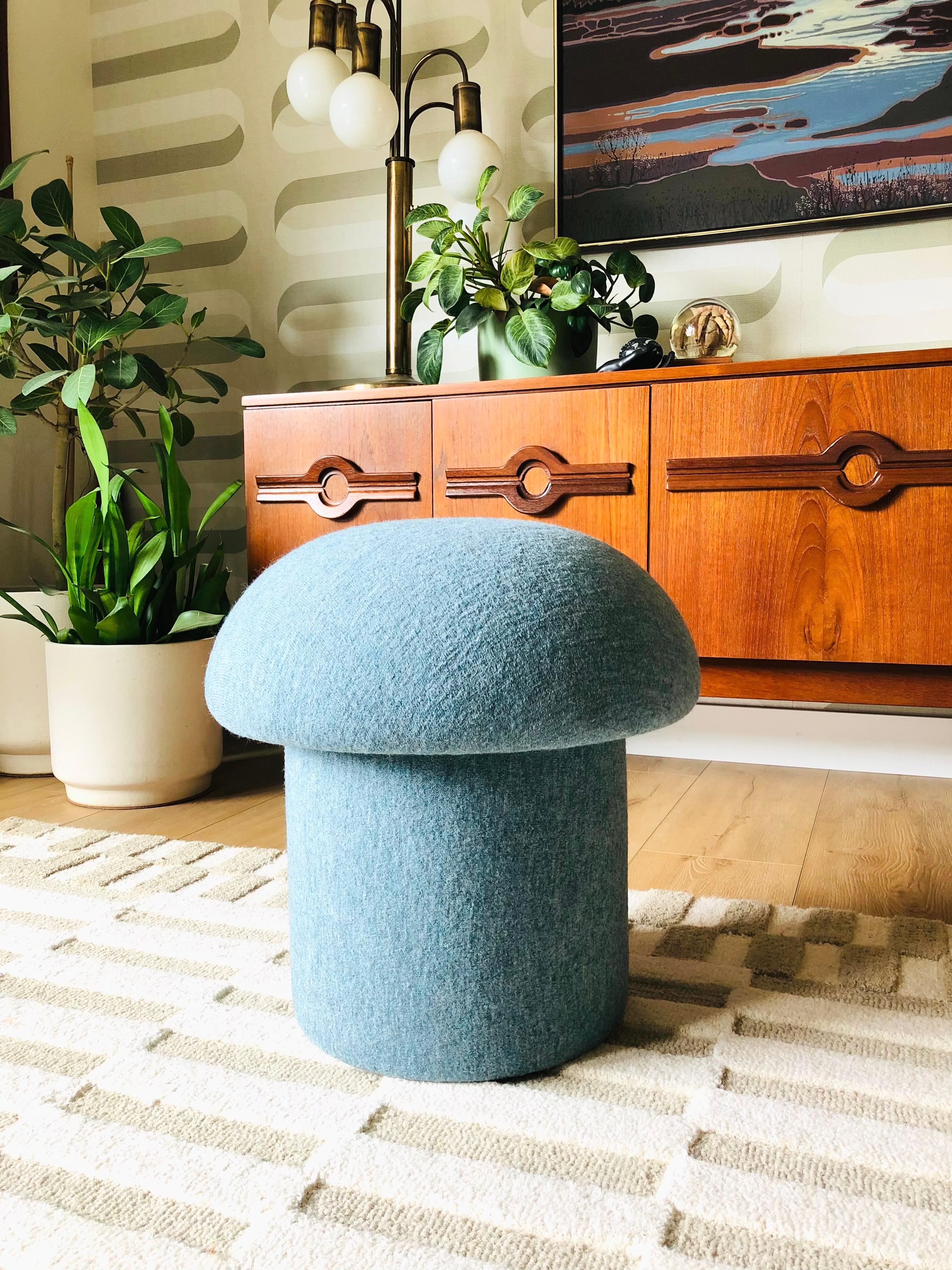 Ein handgefertigter pilzförmiger Ottoman, bezogen mit hellblauem Wollstoff 