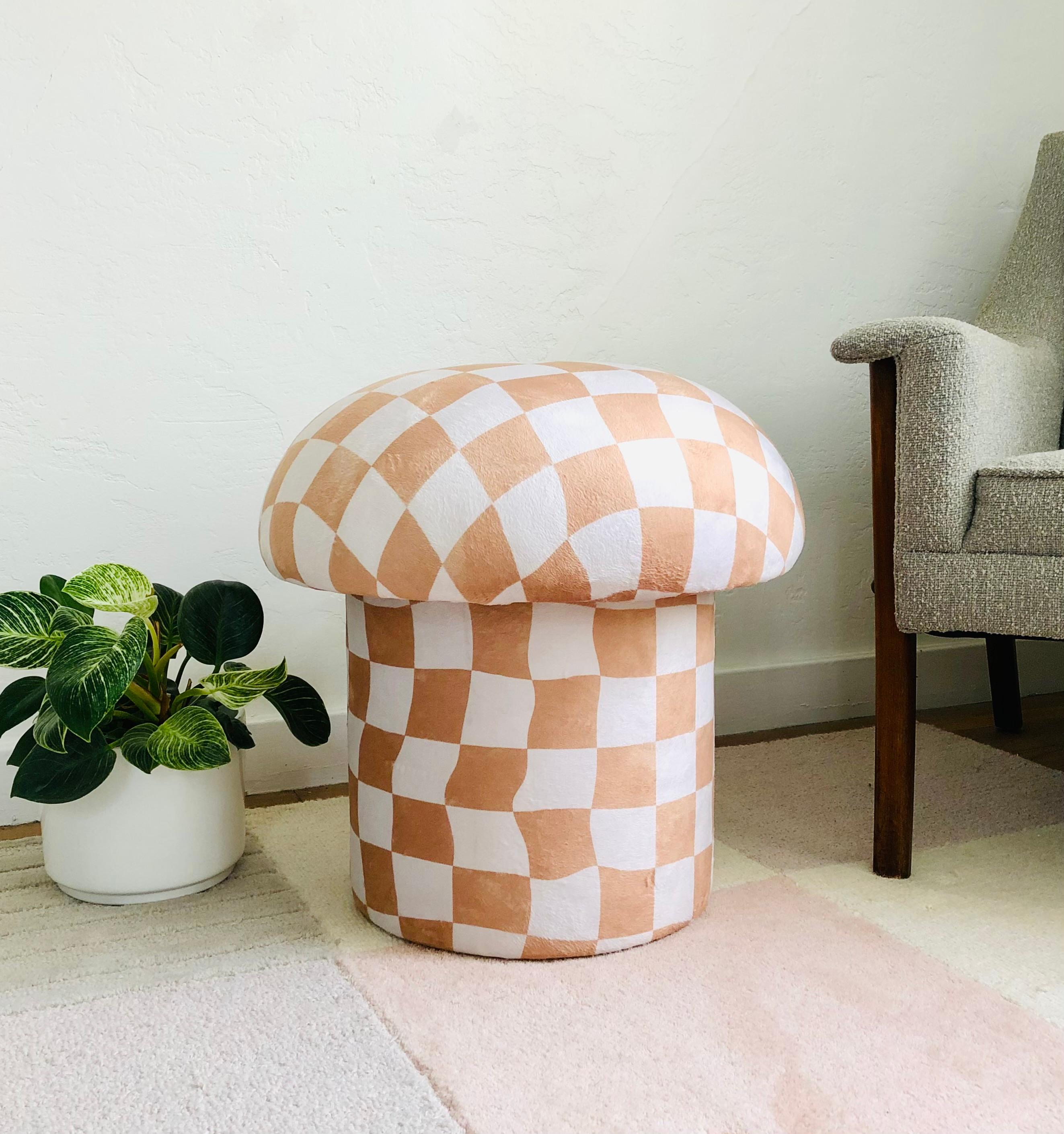 A handmade mushroom shaped ottoman, upholstered in a white and tan warped checkerboard velvet fabric. Perfect for using as a footstool or extra occasional seating. A comfortable cushioned seat and sculptural accent piece.
Mushroom ottomans are made