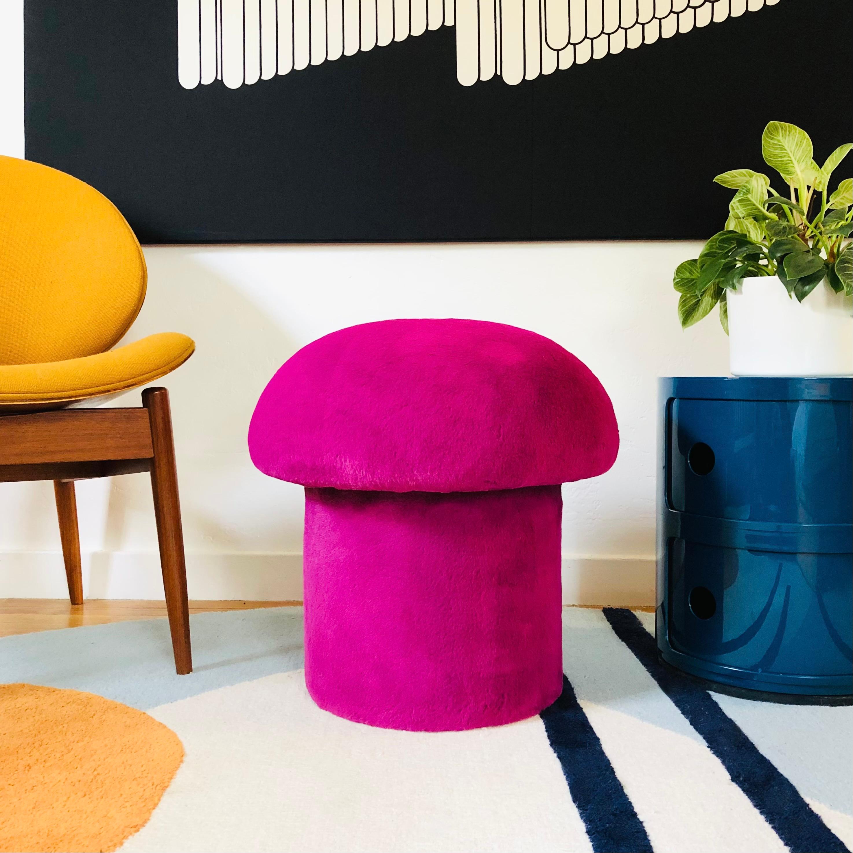 A handmade mushroom shaped ottoman, upholstered in a tourmaline fuchsia colored high pile plush fabric. Perfect for using as a footstool or extra occasional seating. A comfortable cushioned seat and sculptural accent piece.
PLEASE NOTE:
Color