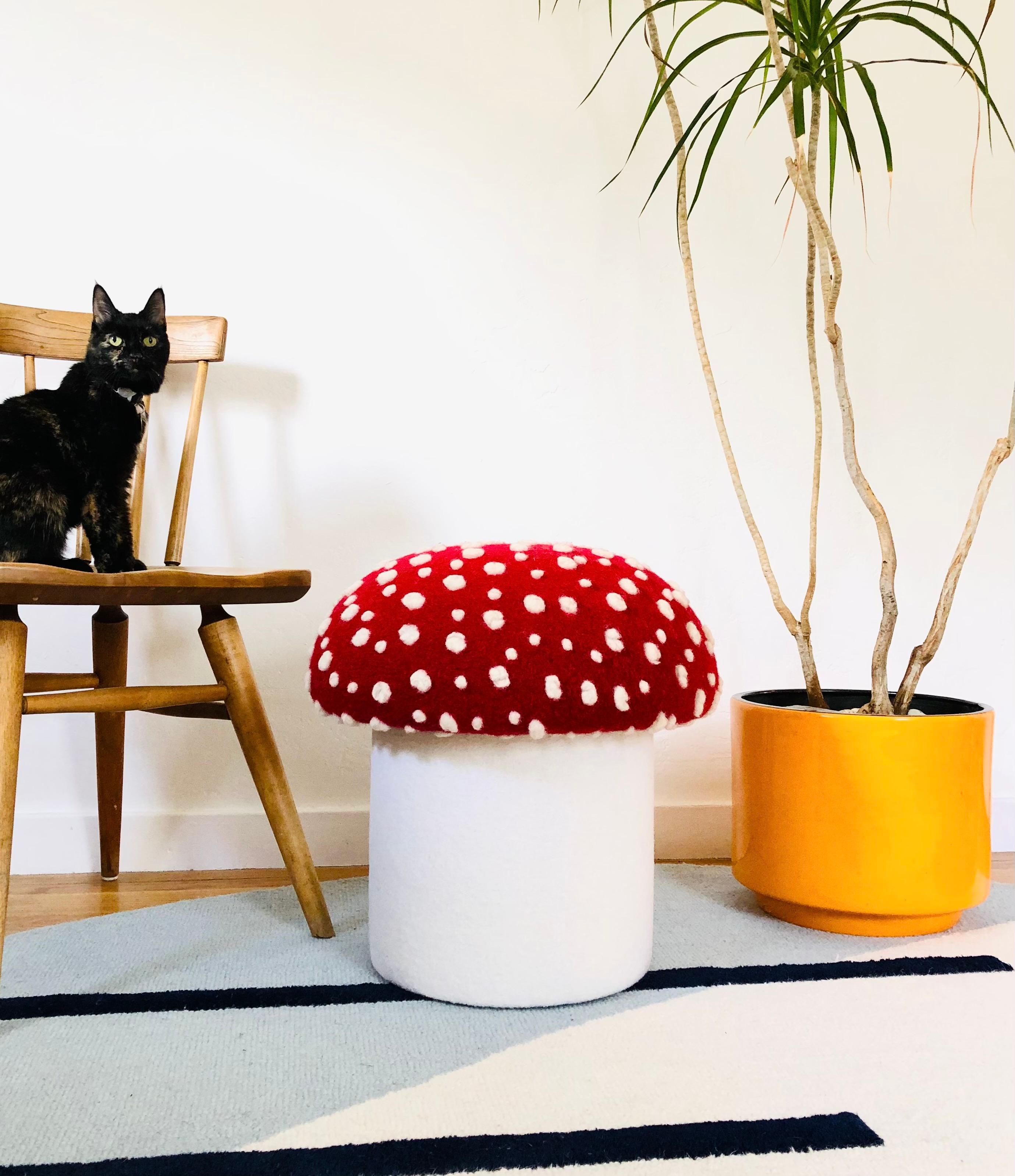 A handmade mushroom shaped ottoman, upholstered in a dotted wool blend fabric to resemble a fly agaric mushroom. Perfect for using as a footstool or extra occasional seating. A comfortable cushioned seat and sculptural accent piece. Mushroom top