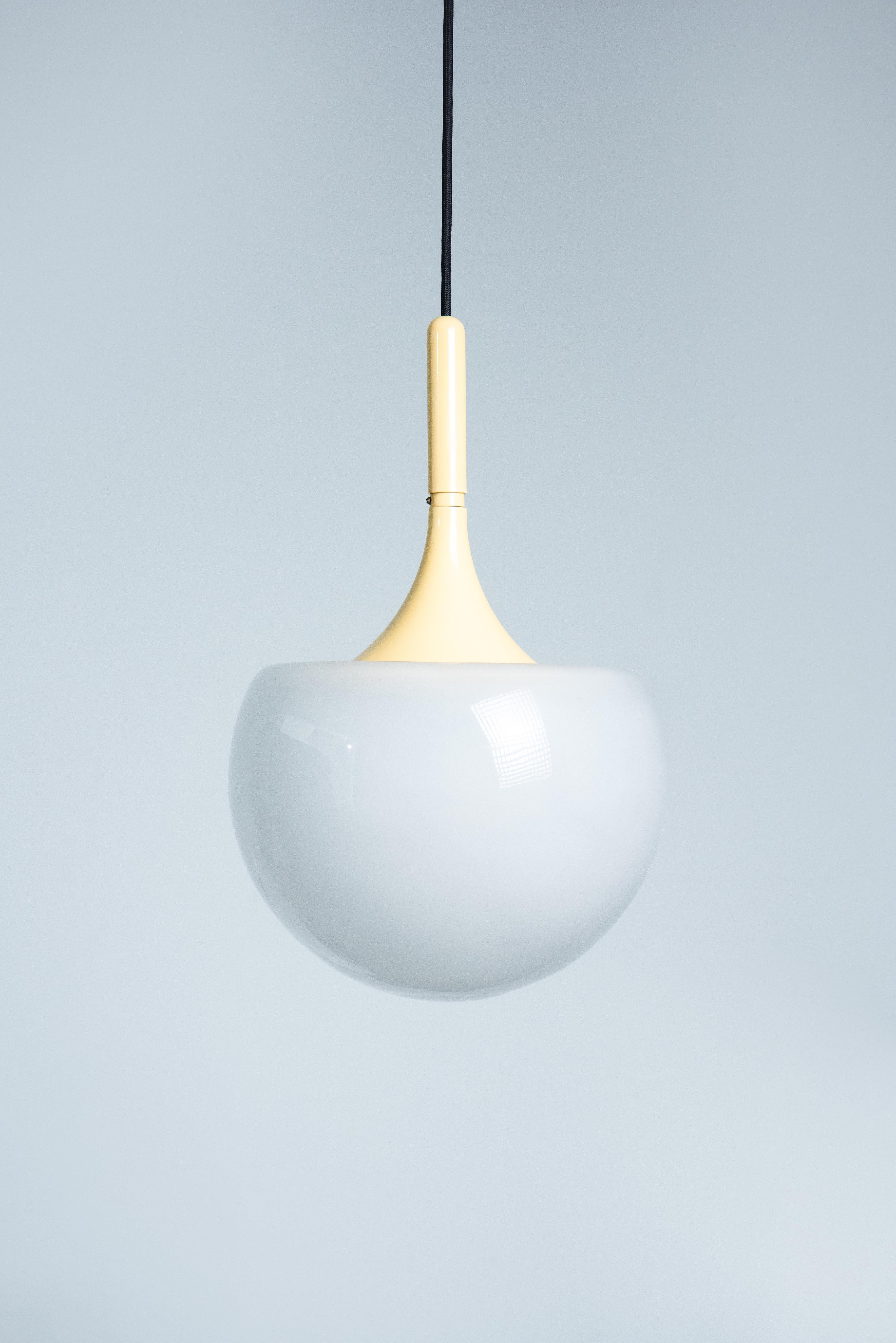 Pendente a forma di fungo in metallo laccato bianco e vetro smerigliato disegnato da Elio Martinelli per Martinelli Luci negli anni '60. La lampada è in condizioni originali con una bella patina. L'elettricità è controllata e funzionante, la presa è