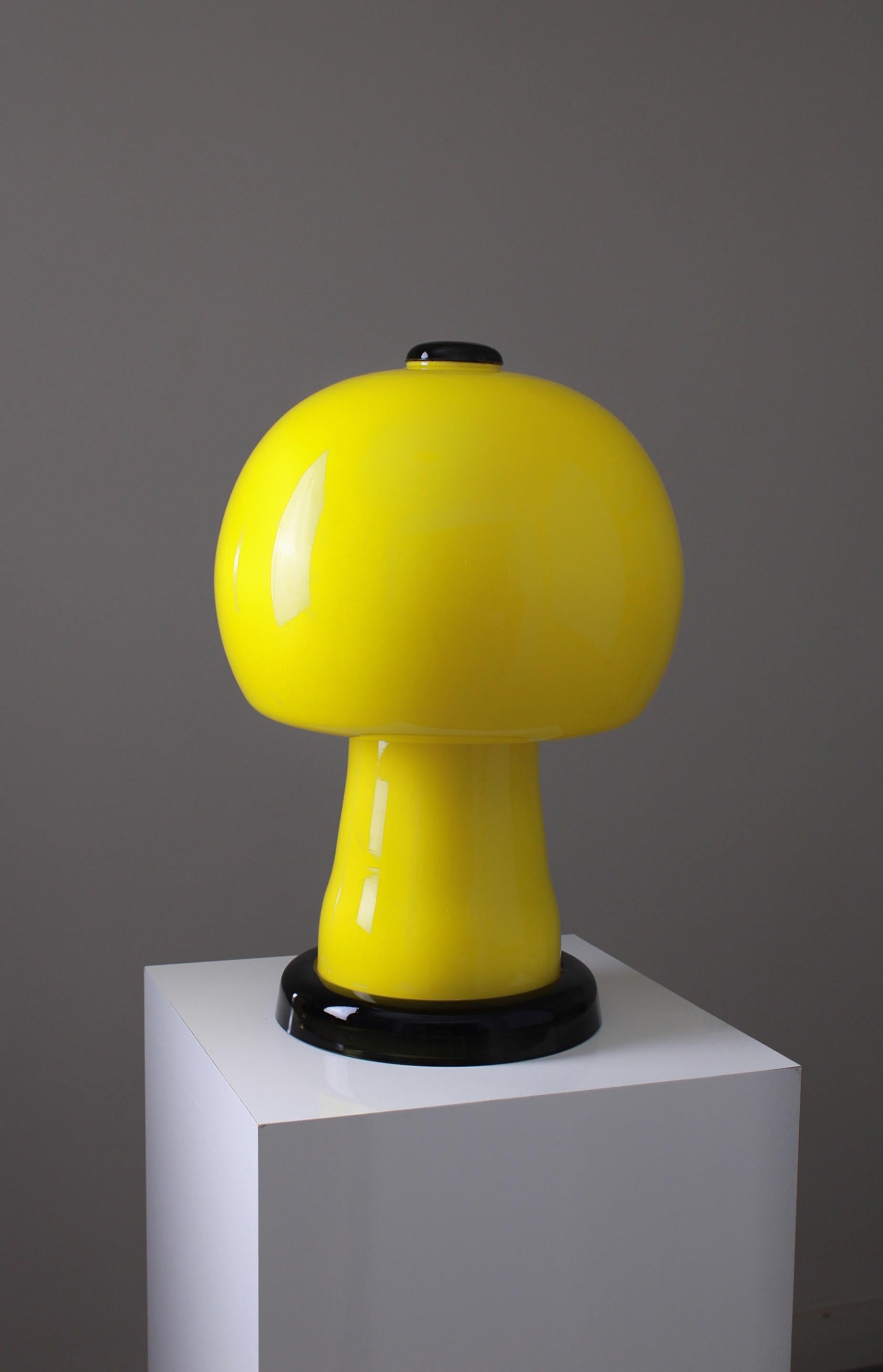 Rare table lamp, designed by Karin Korn for Beleuchtungsglaskombinat Görlitz. Produced in east Germany near the border of Poland. Beautifully made mushroom shaped lamp consisting of one piece of thick glass. Featuring a bright yellow primary color