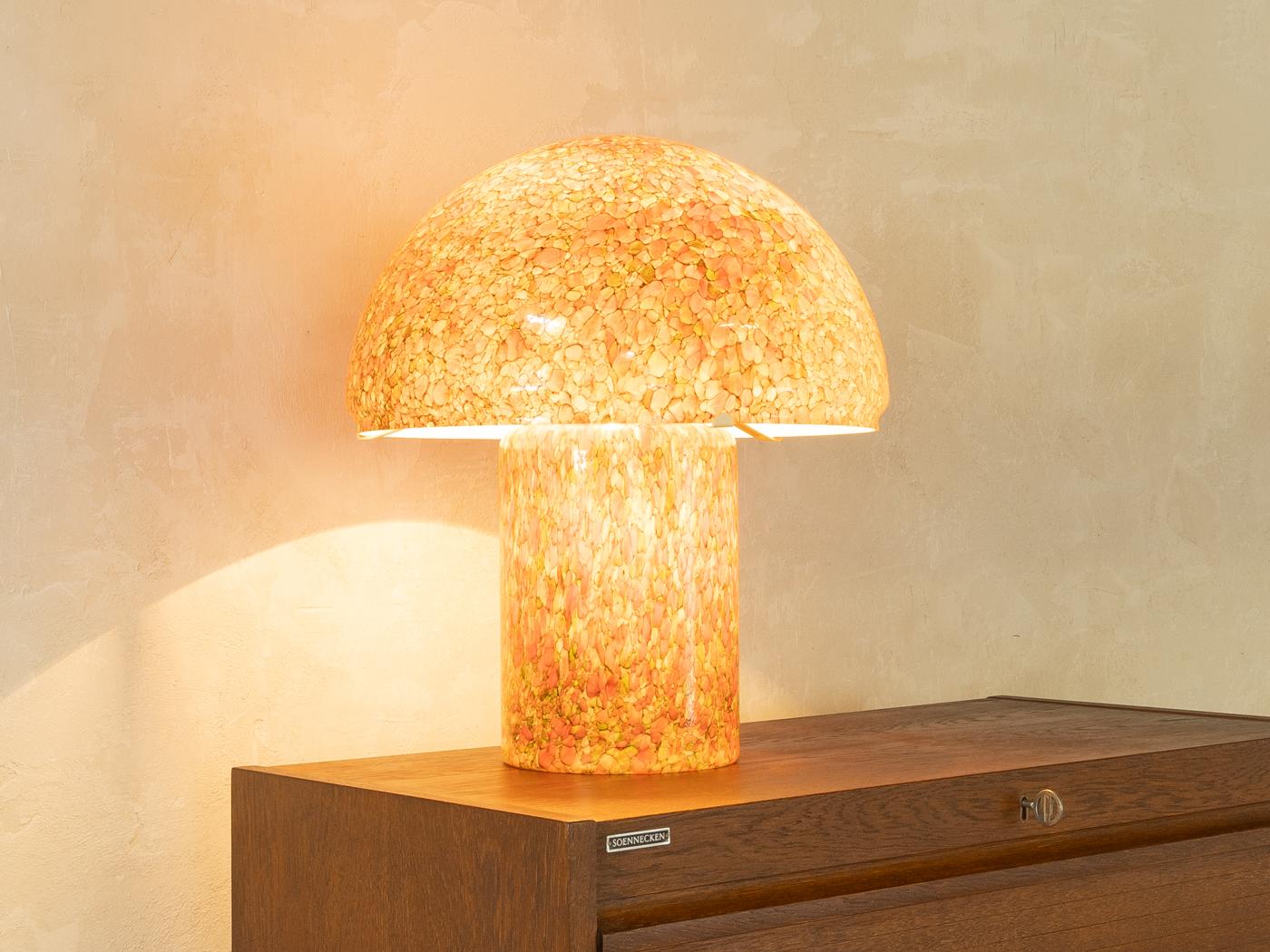 Seltene Pilz-Tischleuchte von Peill und Putzler aus den 1970er Jahren. Hochwertige Konstruktion aus orangefarbenem Glas mit bunten Einschlüssen. Hergestellt in Deutschland.

Qualitätsmerkmale:
sehr gute Verarbeitung
hochwertige