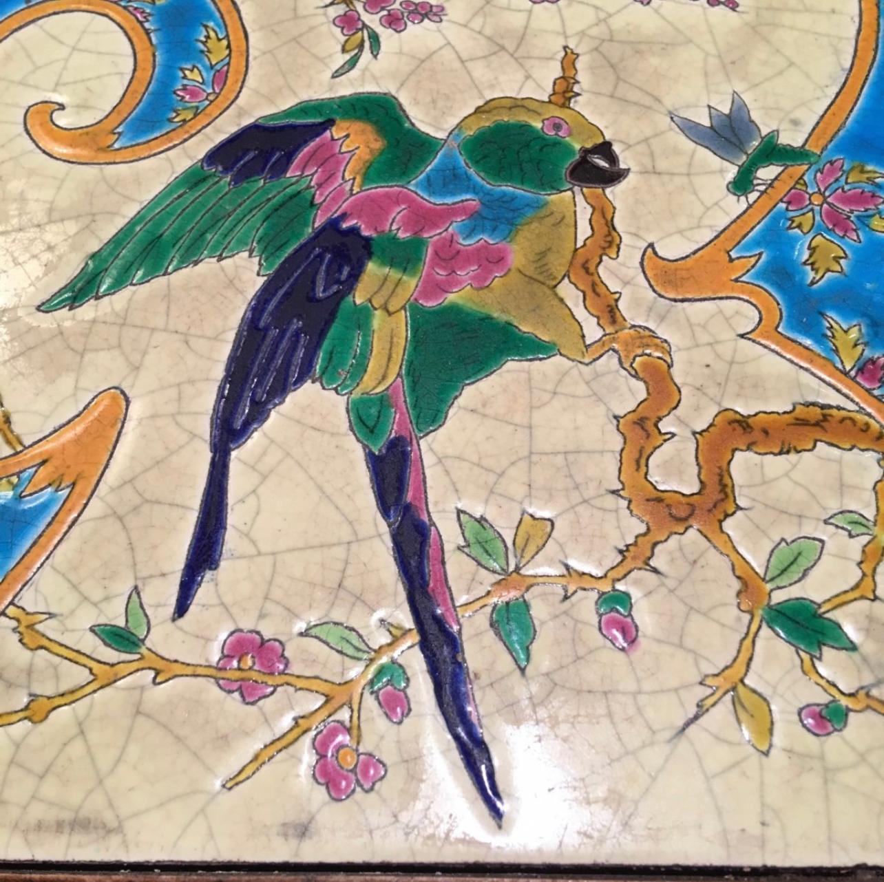 1900s musical trivet, with Longwy enamels decorated with parrot and butterfly. Beautiful colors, works perfectly and very good condition. The little label below where the name of the nursery rhyme is written is no longer there.