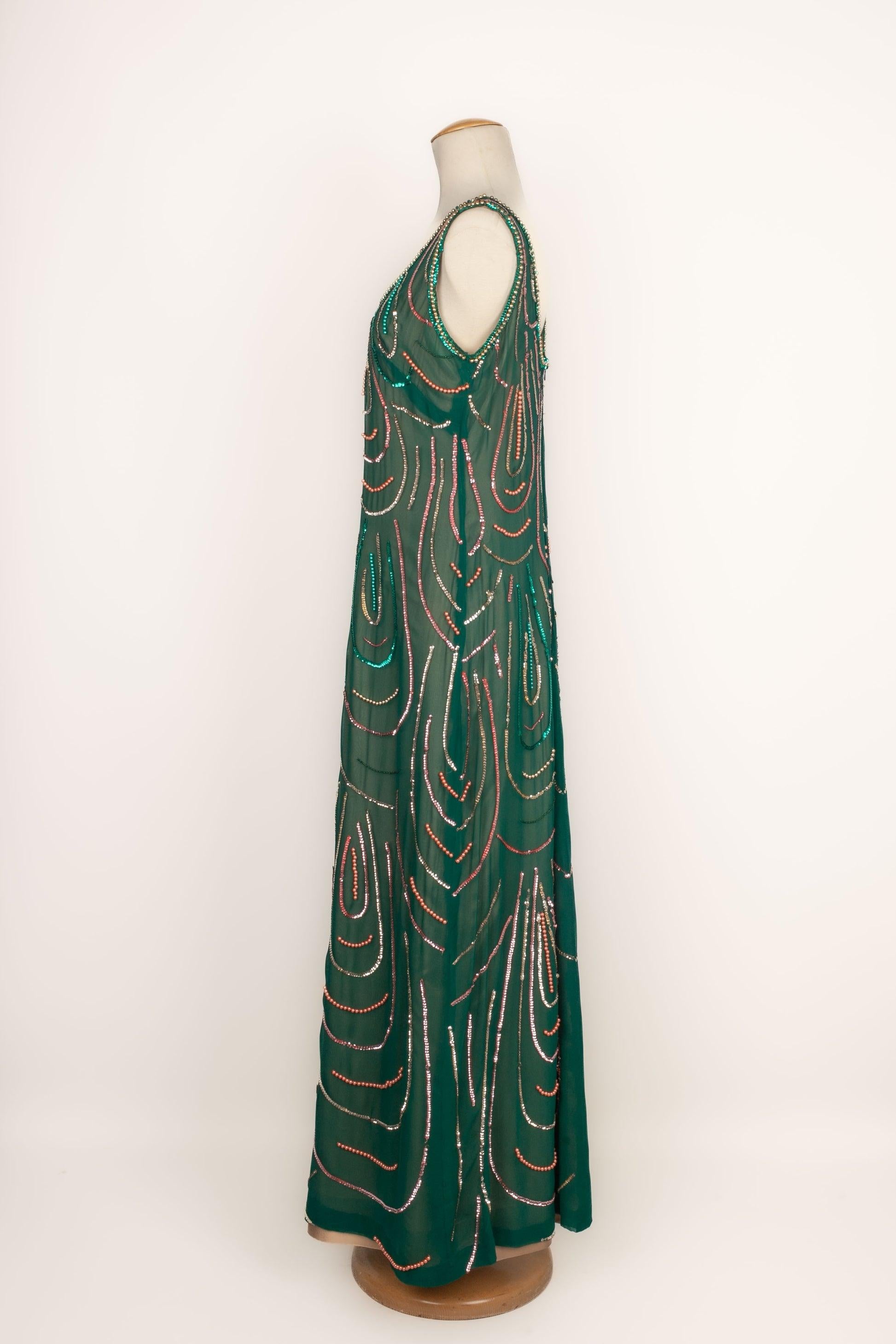 Vestido de muselina verde cosido con lentejuelas y perlas, de los años sesenta. Falta la etiqueta de talla y composición, se ajusta a una 40FR.

Más información:
Estado: Muy buen estado
Dimensiones: Pecho: 45 cm - Cintura: 40 cm - Longitud: 145