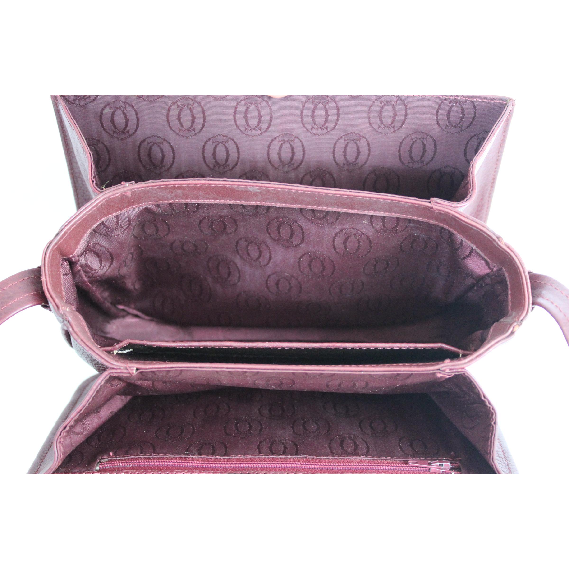 Must de Cartier vintage shoulder bag, burgundy color, 100% hammered leather. Adjustable shoulder strap, 3 compartments inside with dividers. 80s. Made in Italy. Very good vintage condition, some signs of use on the edges, excellent interior.