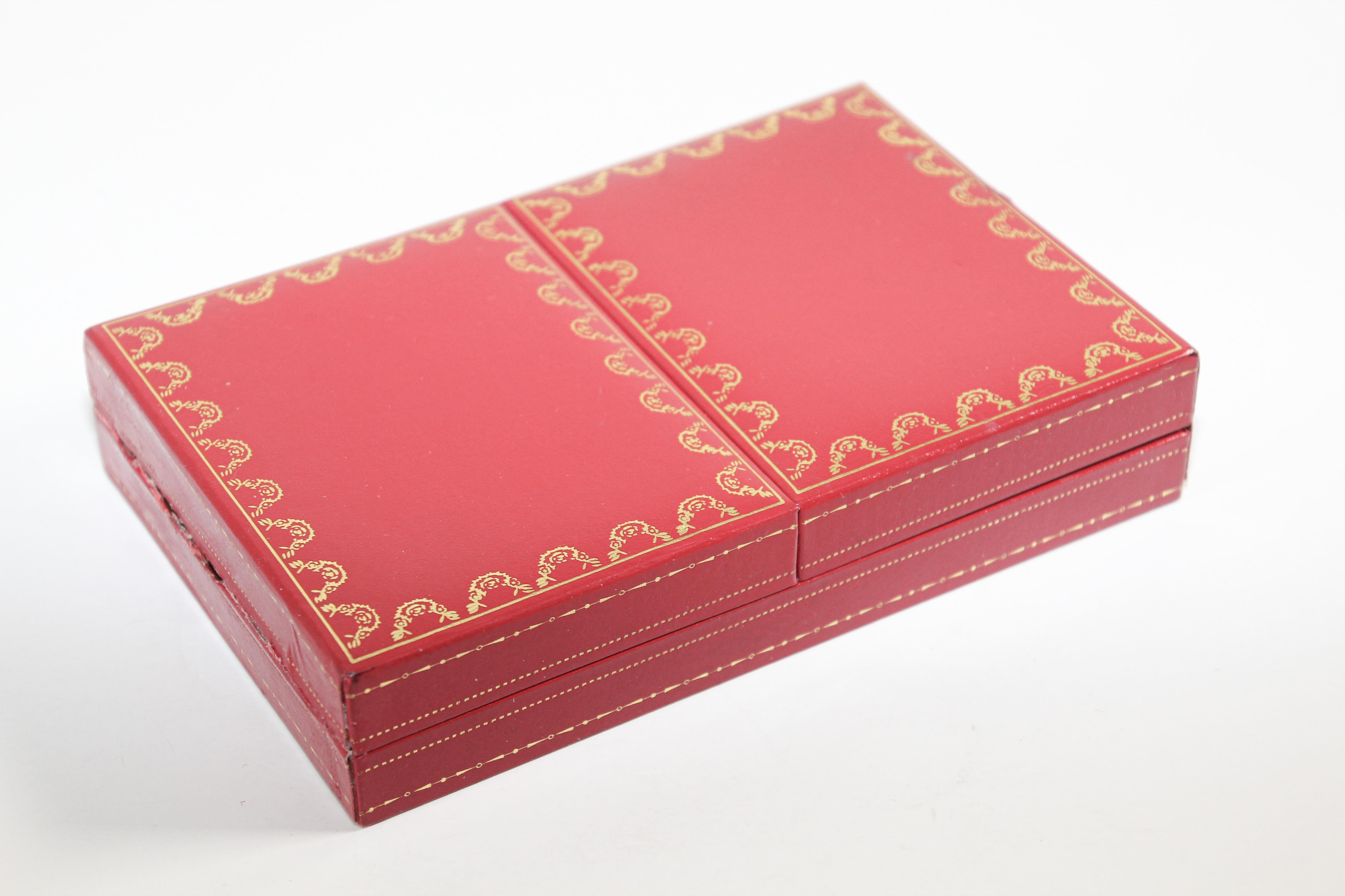 Cartier playing cards, one deck plus joker, poker, bridge playing cards in Cartier red 2-doors case.
Les Must De Cartier playing cards were only sold from 1972-1976.
This silk-lined box of cards with 18-karat gilded corners, printed with the Les