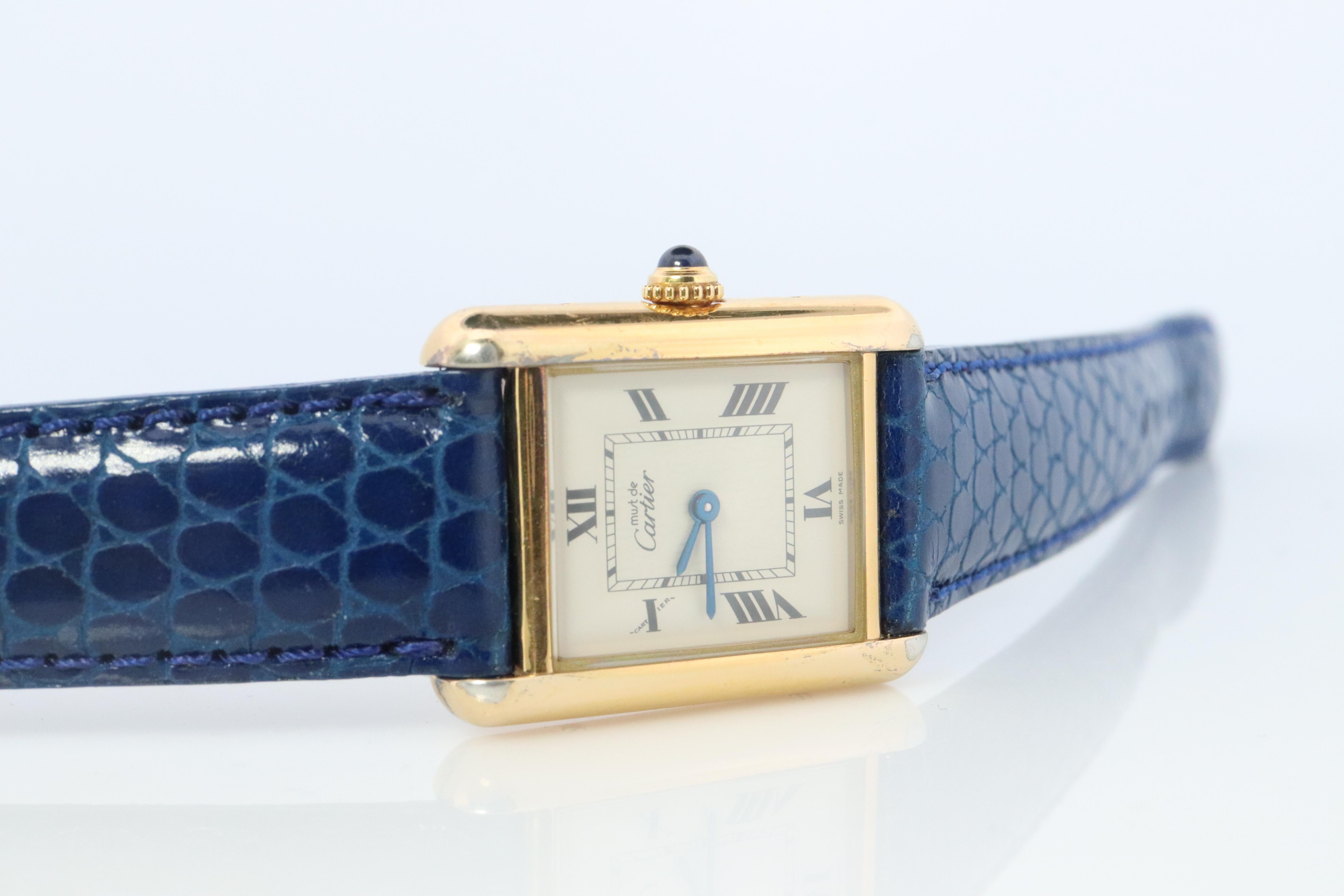 Genuine Cartier watch. Vintage Iconic Tank Argent. Sterling Silver and Gold plated (Vermeil).

Ref 2415

RARE Roman Numbers Dial.

New  Leather Band.

Condition: Original CARTIER Box. New Battery installed.

Details:
22.5mm by 30mm Case
Original Red