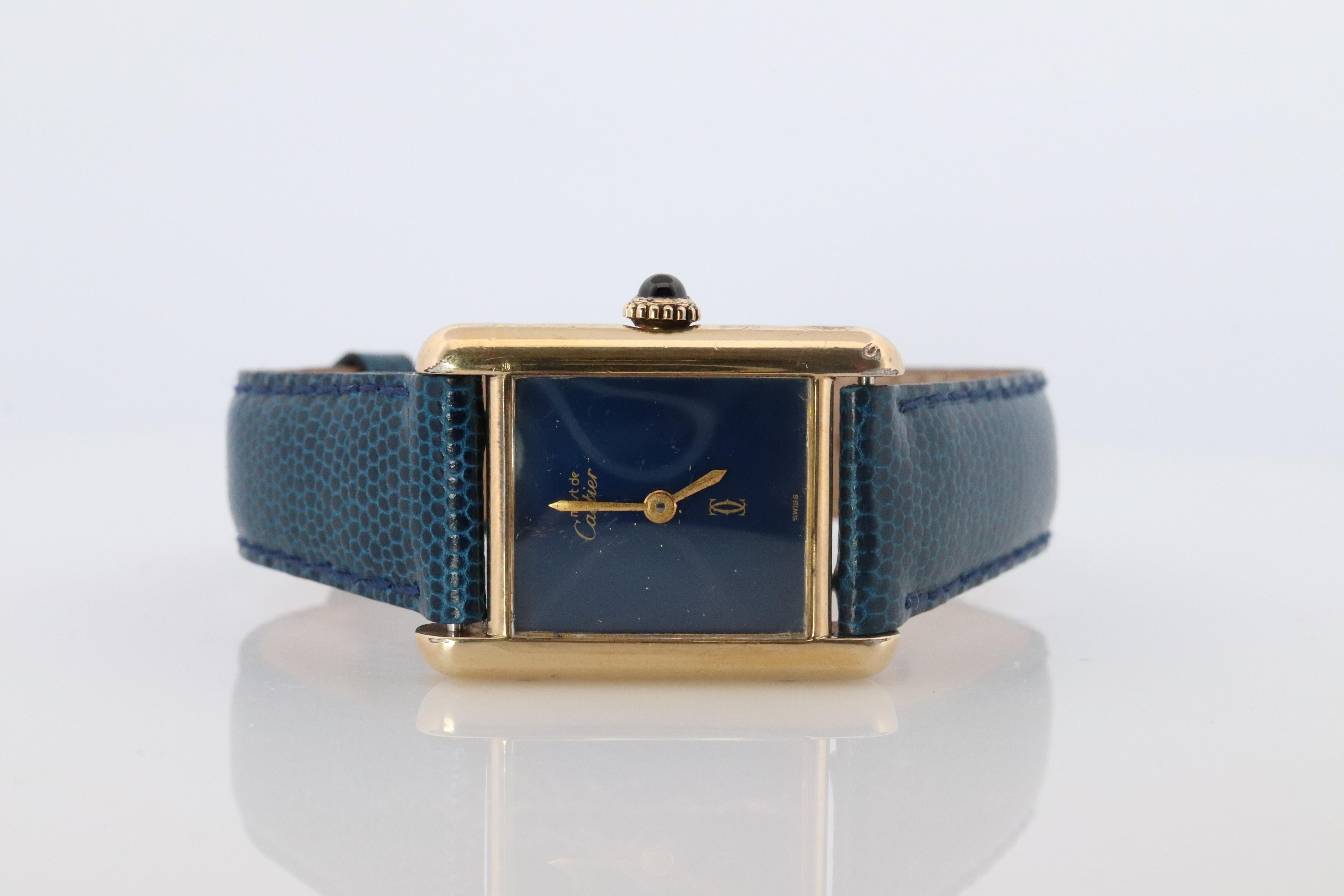 Genuine Cartier watch. Vintage Iconic Tank Argent. Sterling Silver and Gold plated (Vermeil).

RARE Blue Mystery Dial.

Manual Windup Movement

New Gucci Leather Band.

Condition: New battery installed.

Details:
21mm by 28mm Case
Blue Mystery