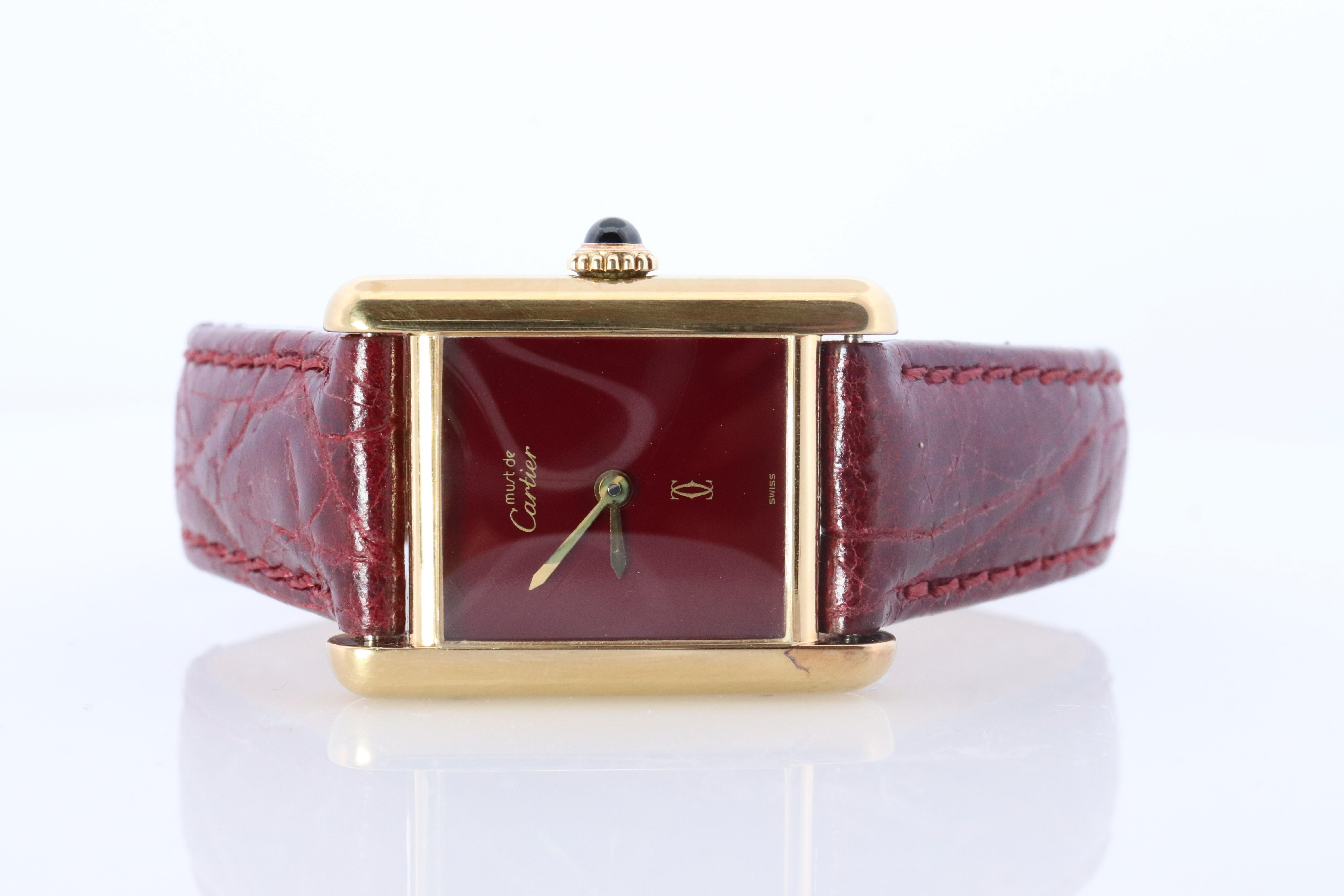 Véritable montre Cartier. Vintage Icone Tank Argental. Argent sterling et plaqué or (Vermeil).

RARE Vin Rouge (Burgandy) Cadran Mystère.

Mouvement de remontage manuel

Nouveau Bandeau en cuir.

Condit : Remontée et maintien de l'heure.

Détails