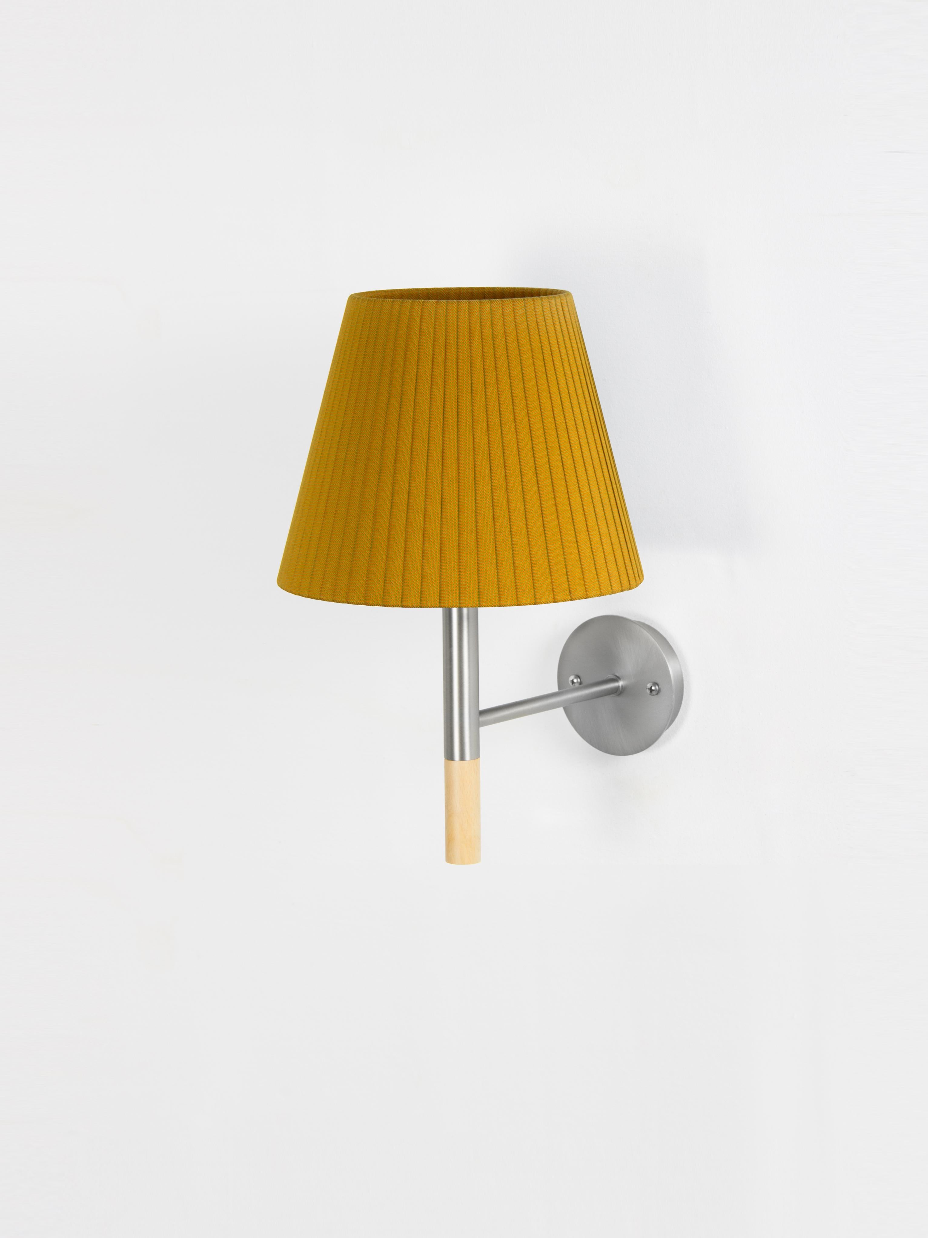 Mustard BC2 wall lamp by Santa & Cole
Dimensions: D 20 x W 26 x H 33 cm.
Materials: metal, beech wood, ribbon.

The BC1, BC2 and BC3 wall lamps are the epitome of sturdy construction, aesthetic sobriety and functional quality. Their various