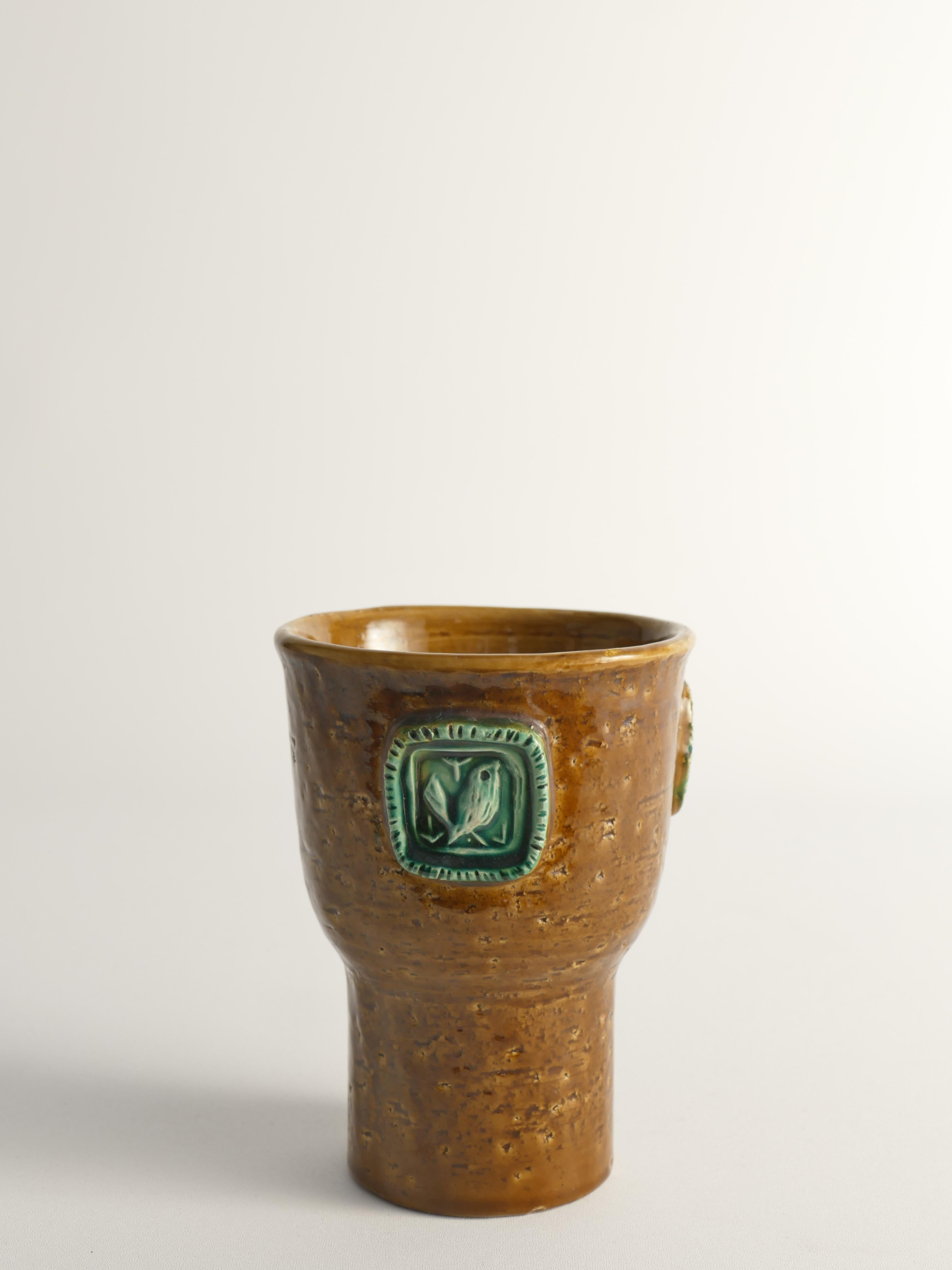 Jarrón Bitossi marrón mostaza con medallones de pájaros verde celadón. Este raro jarrón Bitossi, diseñado por Aldo Londi hacia 1960, presenta un llamativo esmalte marrón mostaza con un medallón de pájaros verde celadón. 

Fabricado en gres chamota