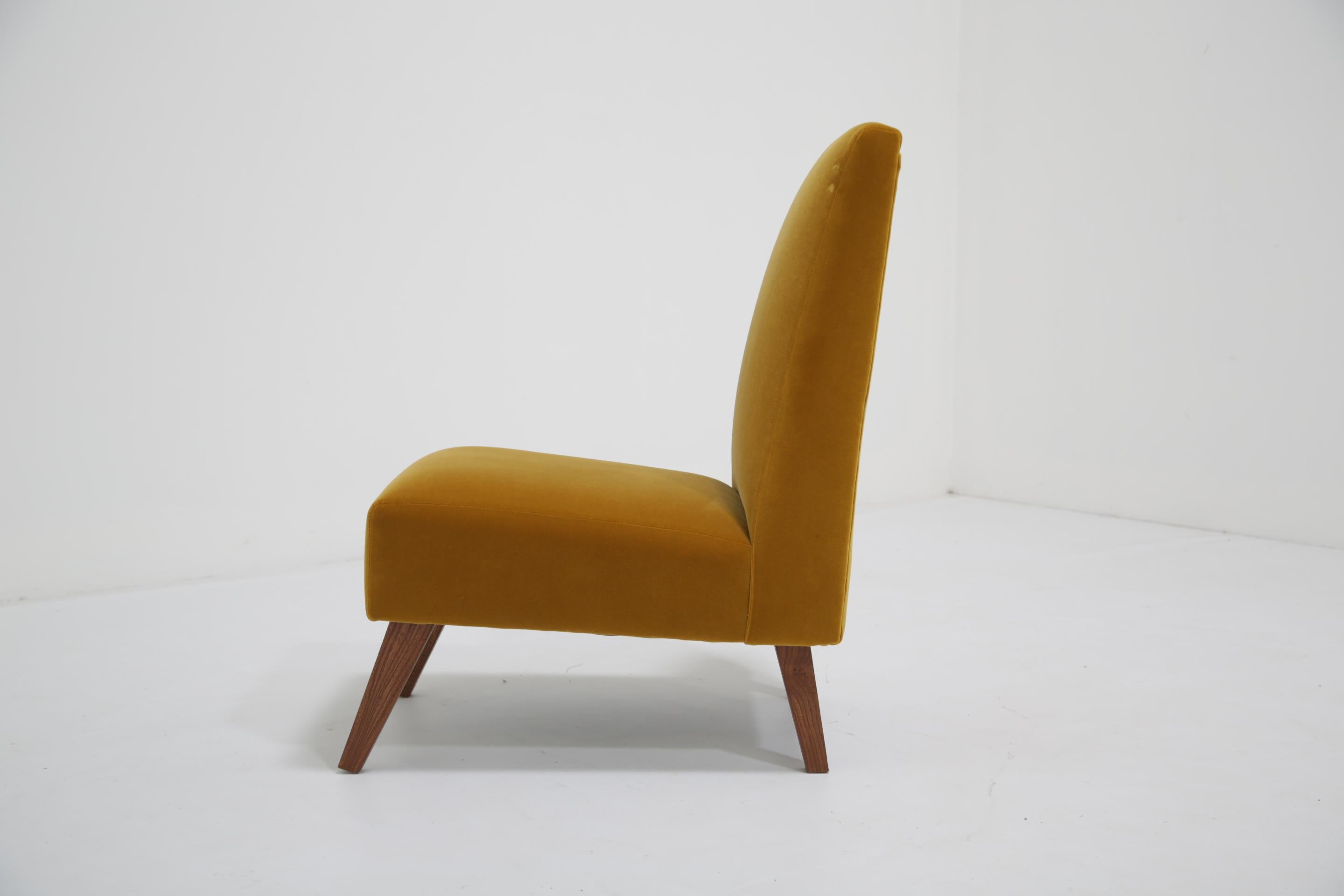 Aporta comodidad a tu dormitorio con esta silla tapizada en terciopelo mostaza dorado, que tiene unas bonitas patas de madera extendidas con el asiento y el respaldo ligeramente inclinados y se ha tapizado en un agradable y exuberante terciopelo de