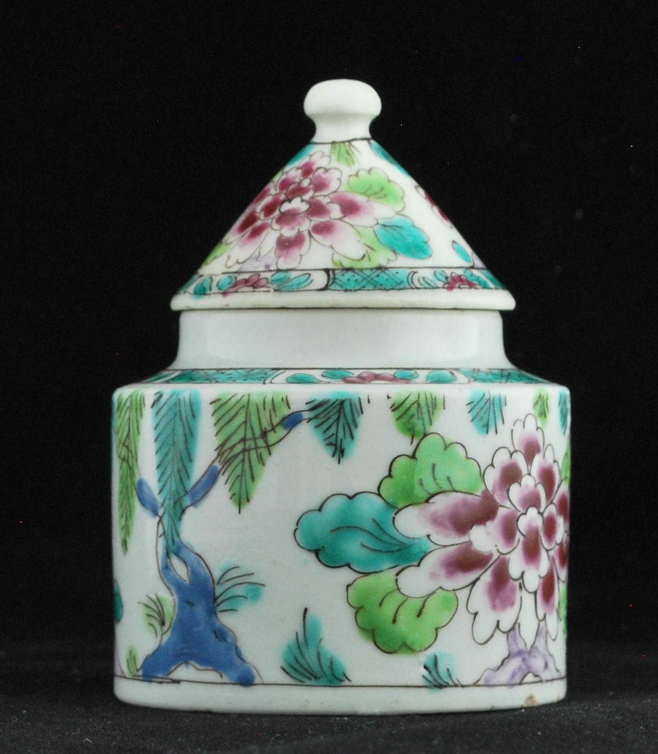 Of cylindrical form with loop handle and conical ‘hops oven’ cover with ball knop. The whole painted with pendant fronds and with a diaper and flowerhead border.

An earlier pot, circa 1750, of slightly more compressed form, decorated in blue