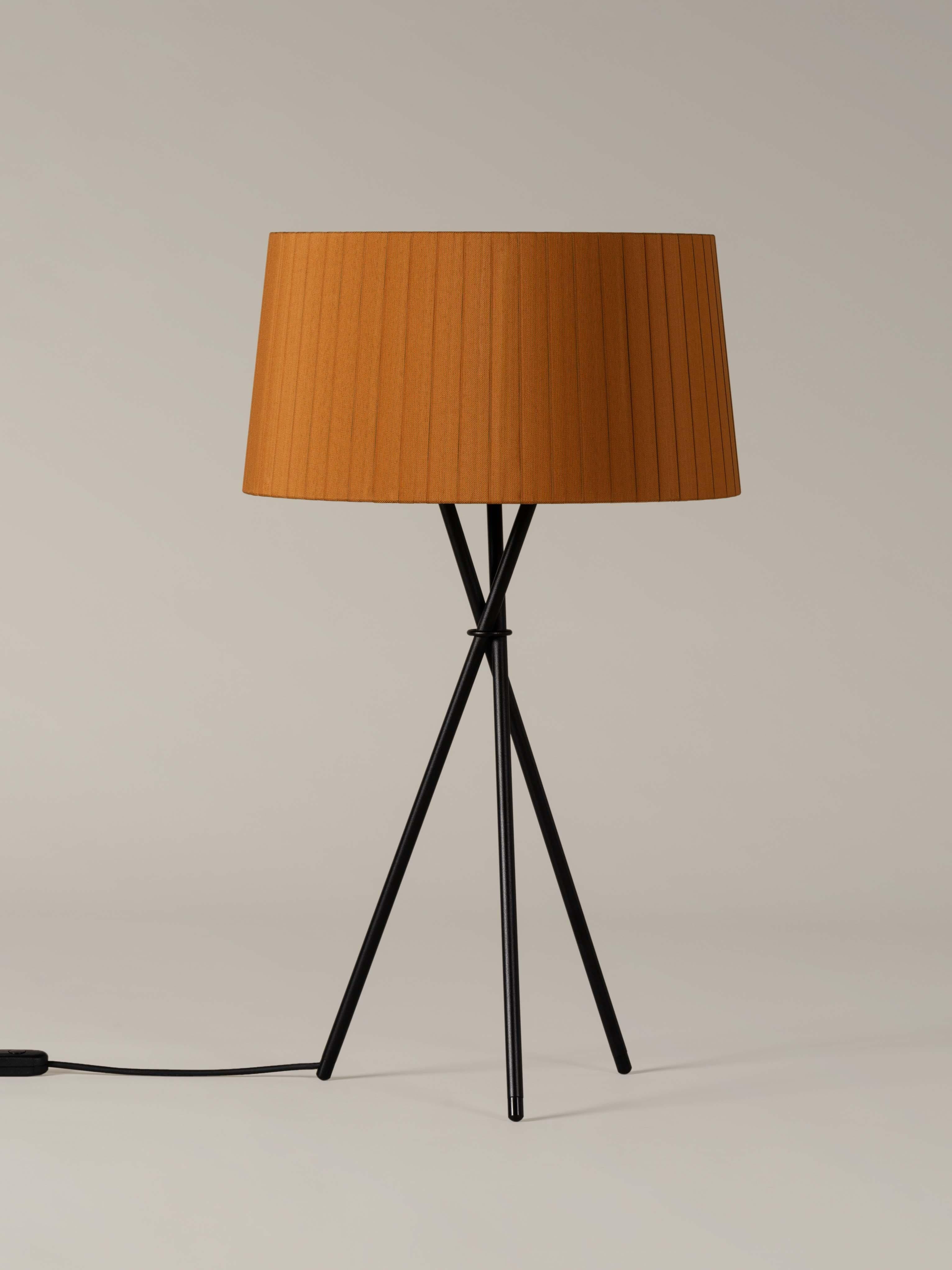 Mustard trípode G6 table lamp by Santa & Cole
Dimensions: D 45 x H 75 cm
Materials: Metal, ribbon.
Available in other colors.

Trípode humanises neutral spaces with its colourful and functional sobriety. The shade is hand ribboned and its base