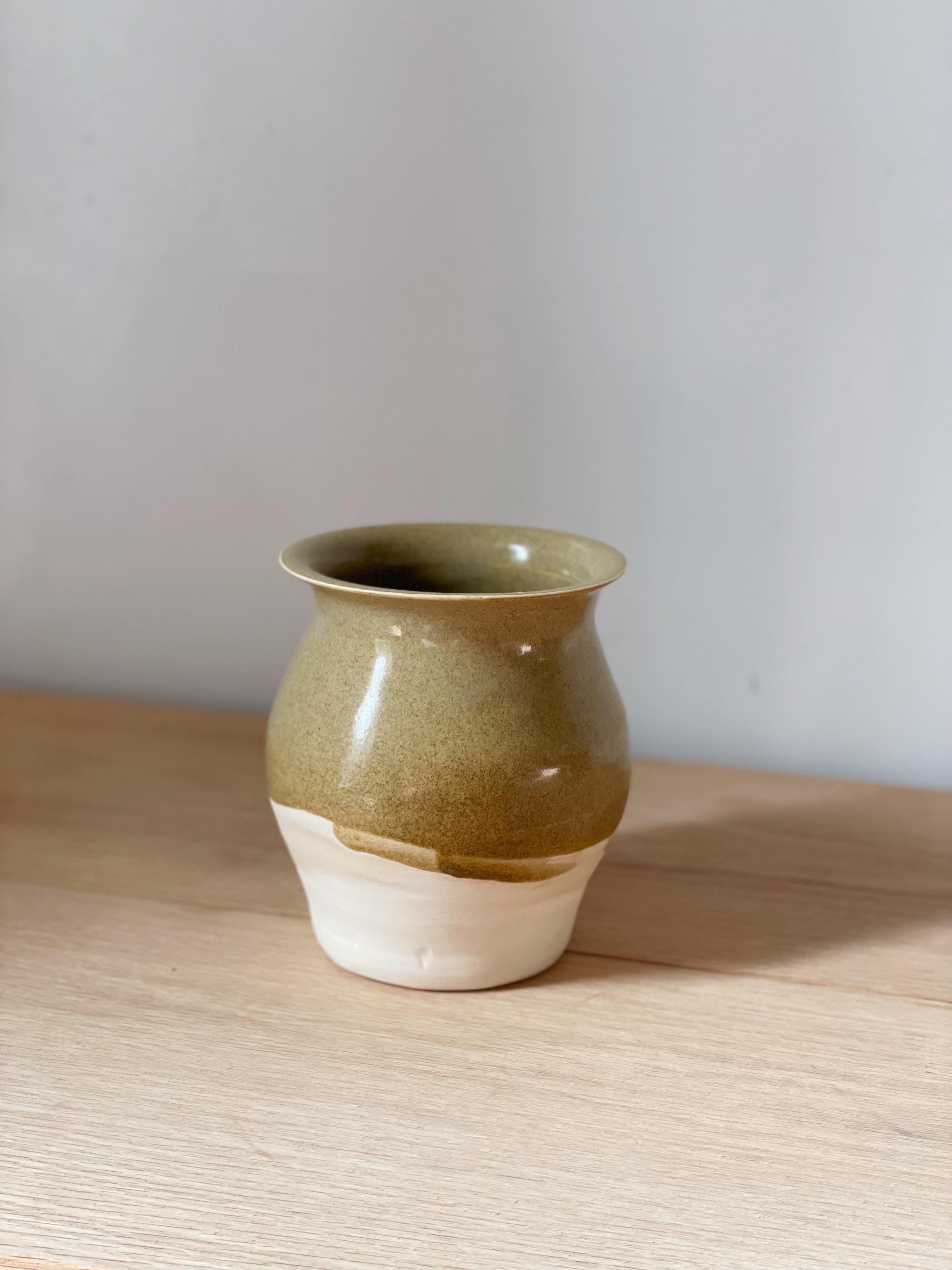 mustard vessel - A wheel thrown vase, with a bulbous body, and a flare at the lip. This piece is made with white stoneware and paired with a delicious mustard glaze, that has a slight texture to it. The glaze has a warm tone overall, and covers most