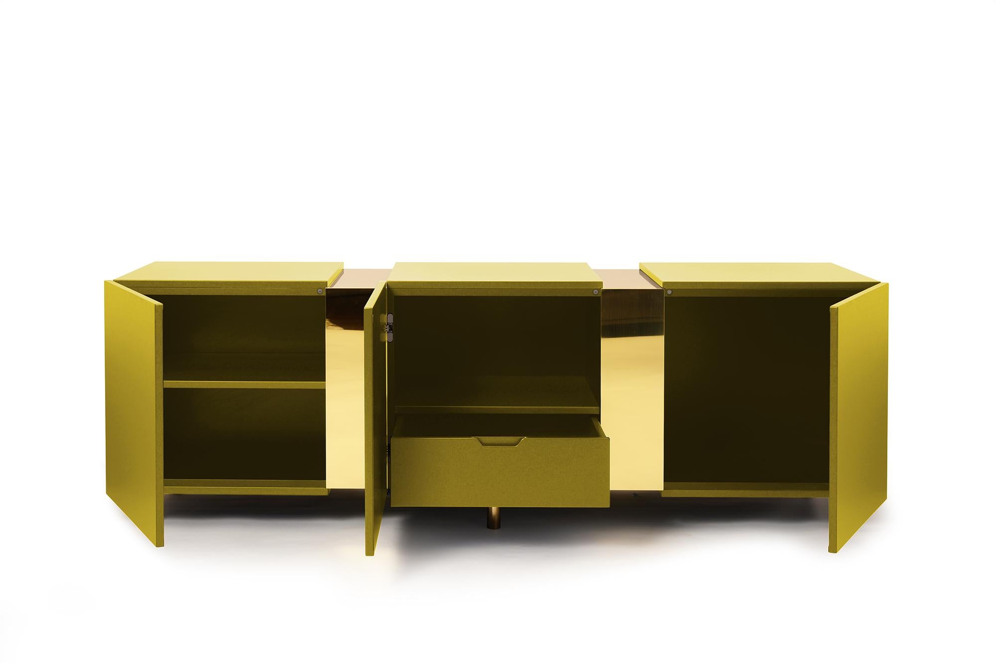 Eunduetrè is a low storage system which punctuates the space and plays with contrasting effects. Extremely simple in its geometric shapes, this sideboard/credenza alternates colorful cubes in matte lacquered wood, with sections of bent brass sheet