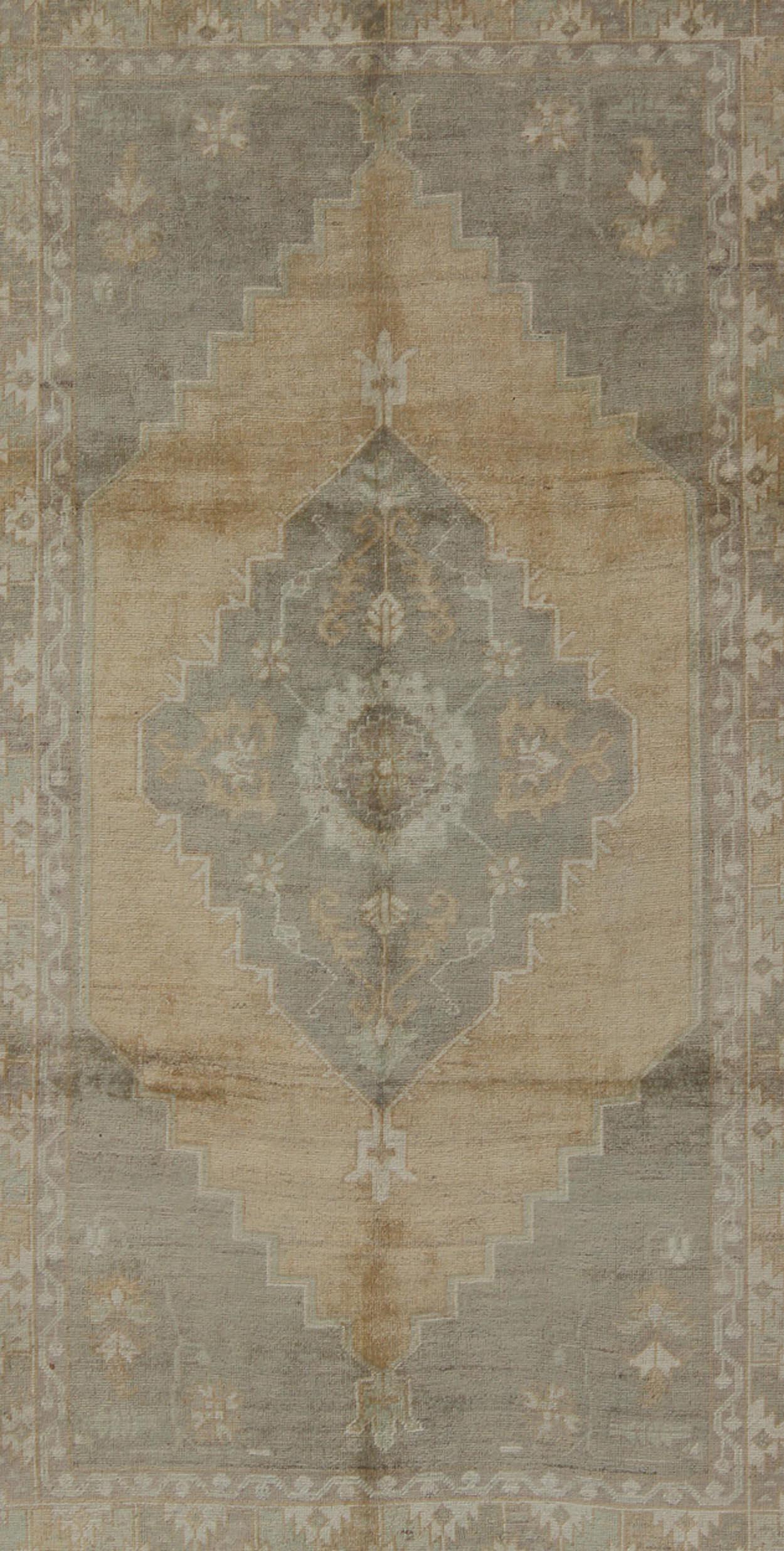 Measures: 5'5 x 9'4

This muted Turkish Oushak rests beautifully on a grounded camel-colored field. An understated medallion is well-balanced by four organic corner motifs, all characterized by the same muted colors. This piece remains elegantly