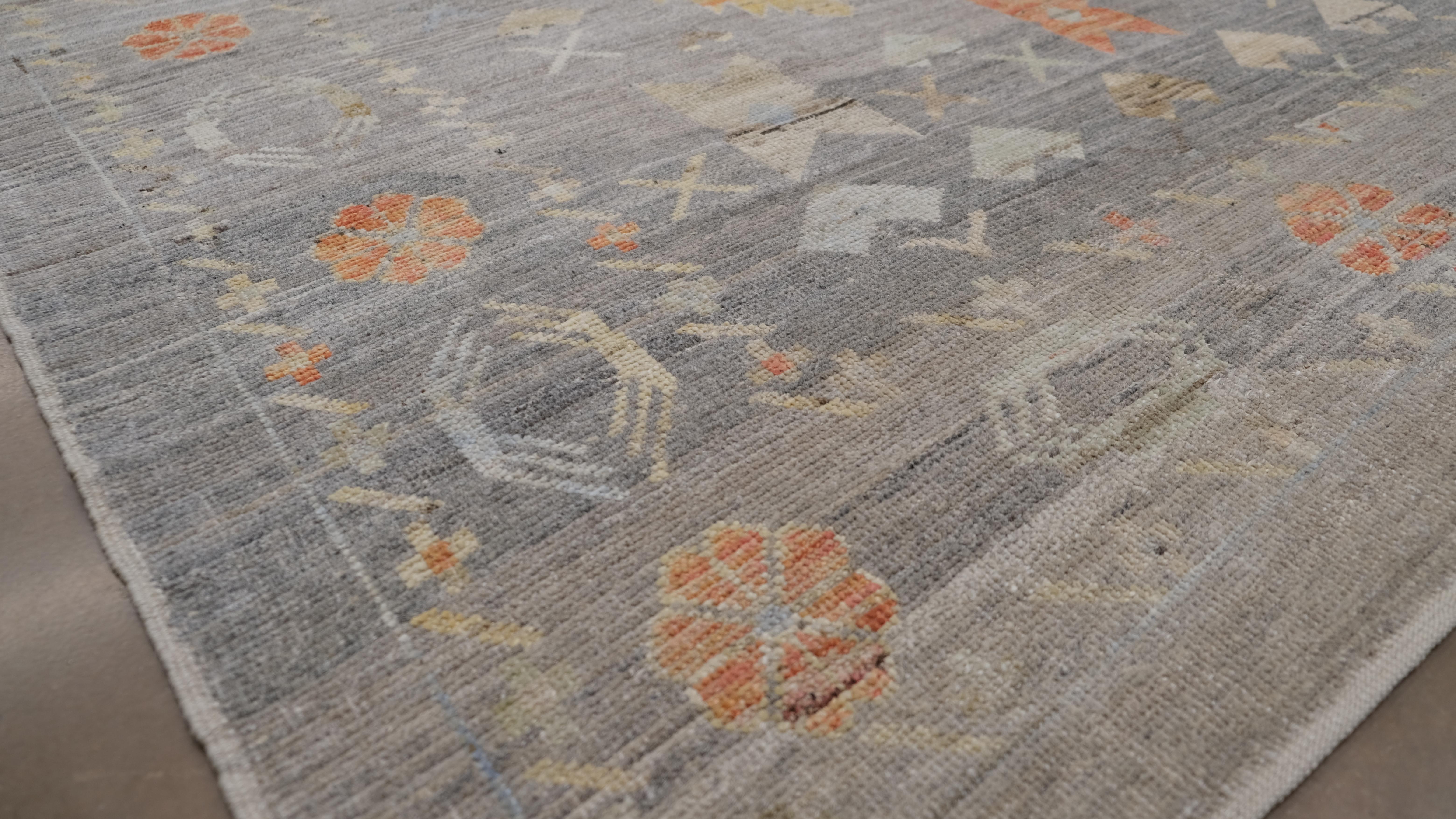 Rehaussez votre intérieur avec le riche héritage et la beauté intemporelle de ce tapis en laine noué à la main. Doté d'un superbe motif oushak tribal d'inspiration vintage, ce tapis présente un ensemble complexe de motifs géométriques et floraux,