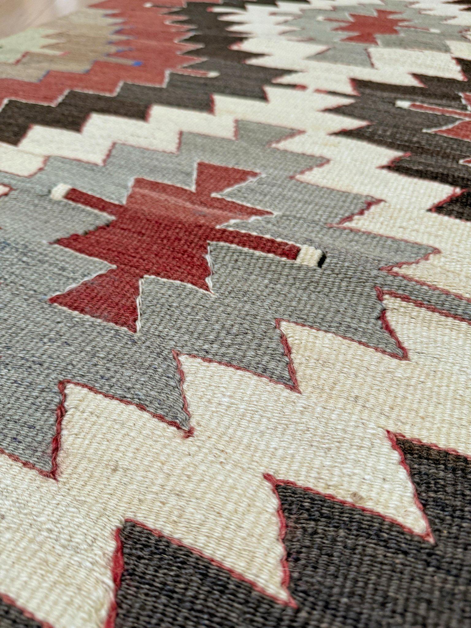 Dieser in der südtürkischen Region Mut handgewebte Kelim aus der Mitte des Jahrhunderts weist ein kraftvolles Stufenmedaillonmuster auf, das wegen seiner Symmetrie und seines kühnen grafischen Rhythmus oft mit der Navajo-Weberei verglichen wird. Das