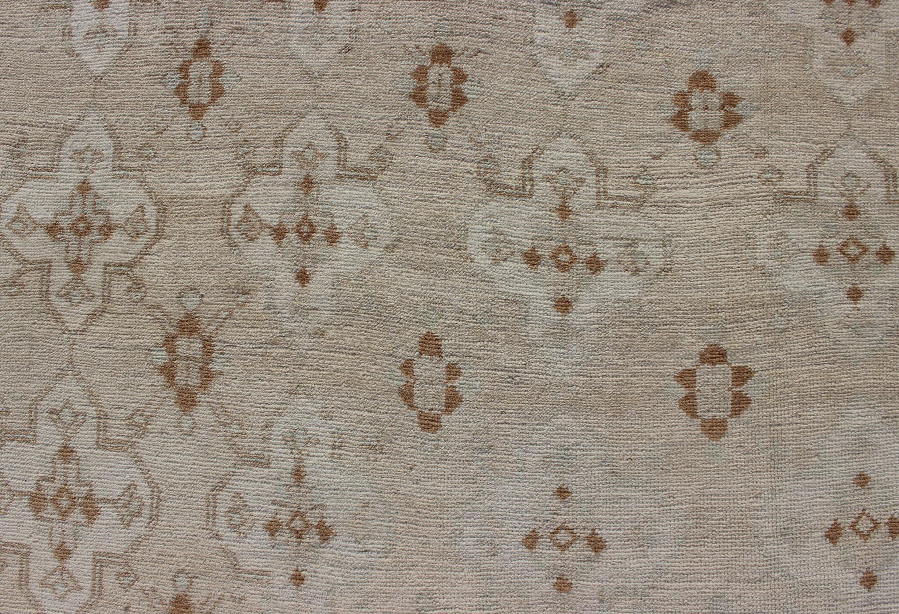 Muted Oushak with All-Over Tribal Design in Light Tones of Taupe and Browns In Good Condition For Sale In Atlanta, GA