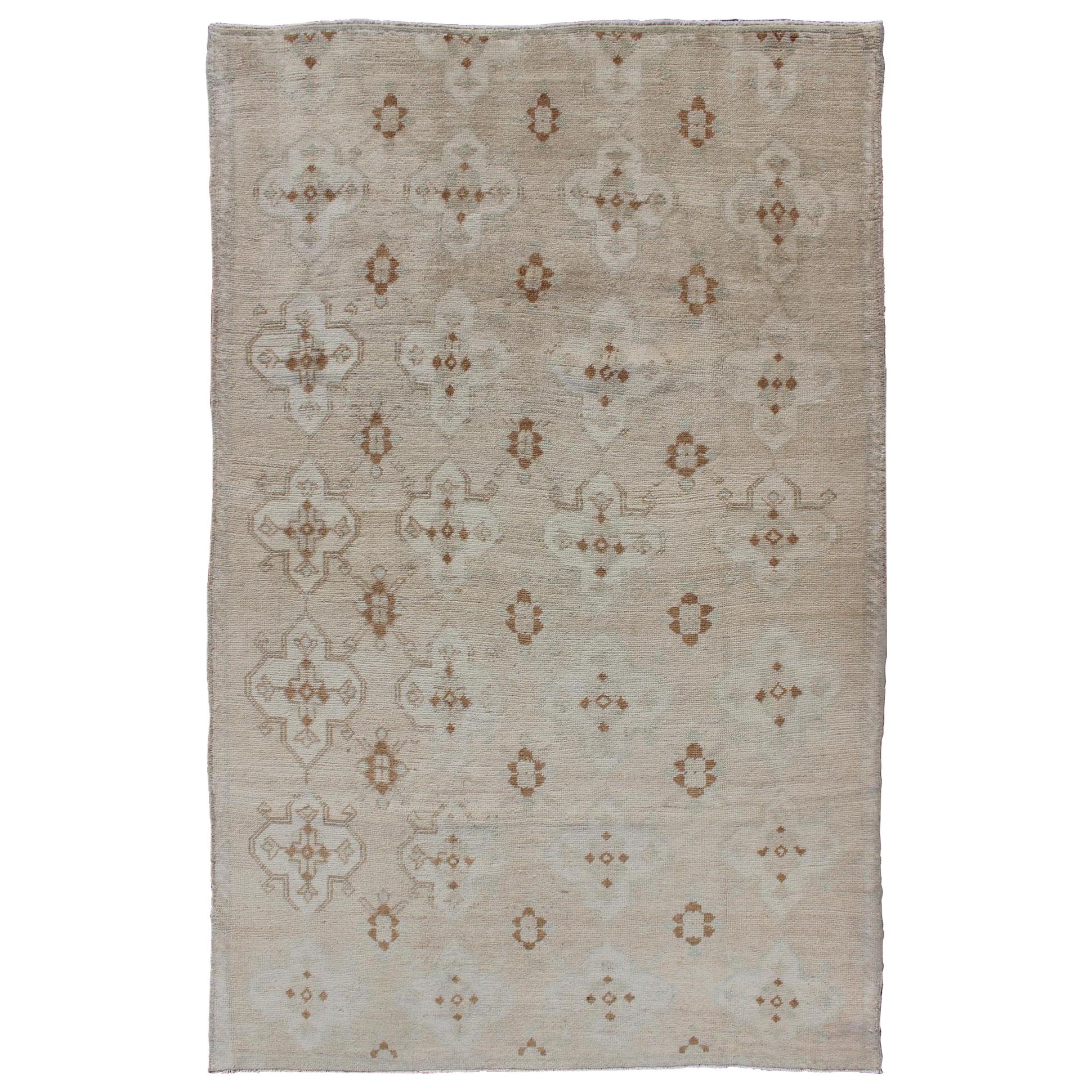 Muted Oushak with All-Over Tribal Design in Light Tones of Taupe and Browns For Sale