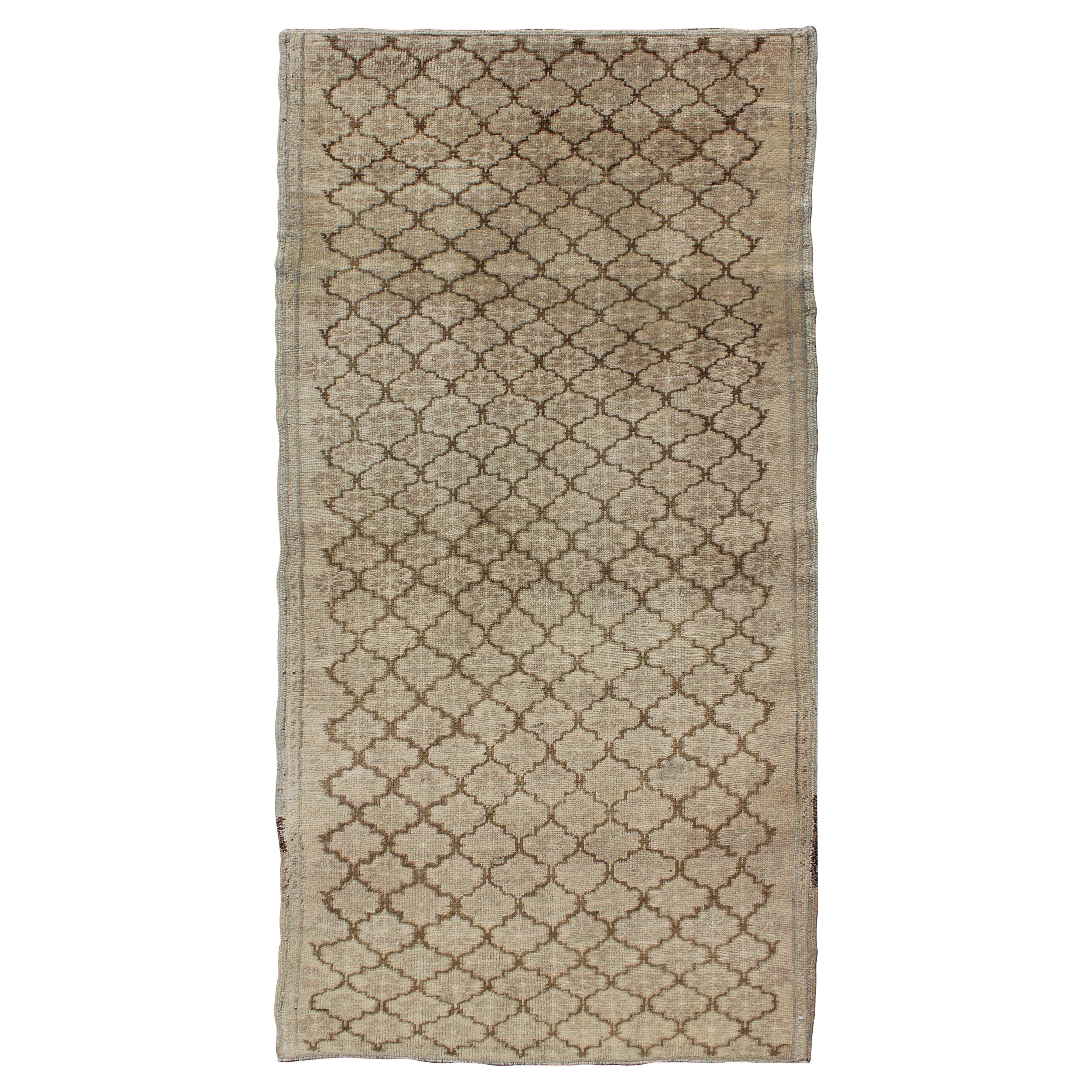 Oushak sourd avec motif tribal sur toute sa surface dans des tons clairs de taupe et de brun